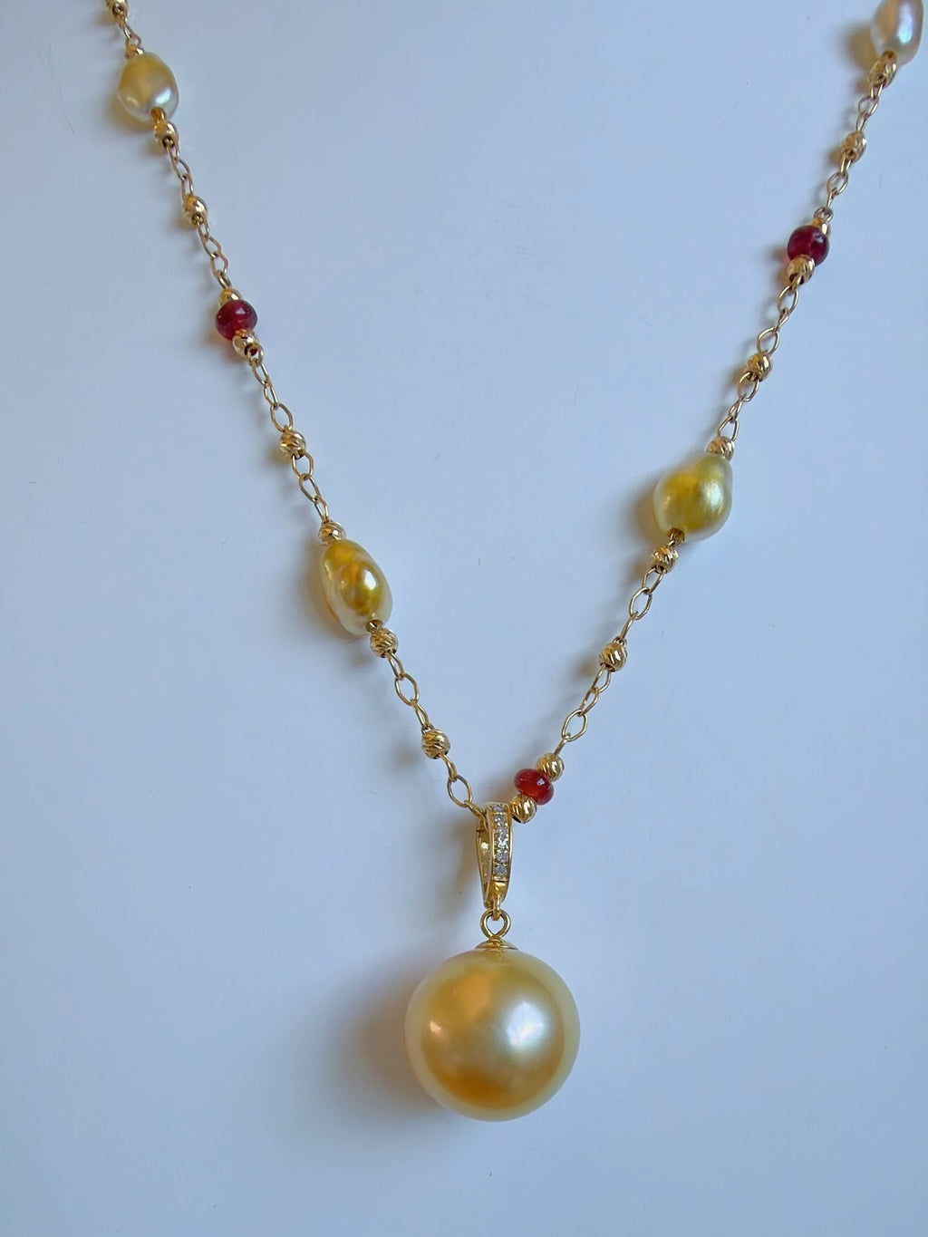Gold pearl pendant necklace with red and yellow gemstone bead accents