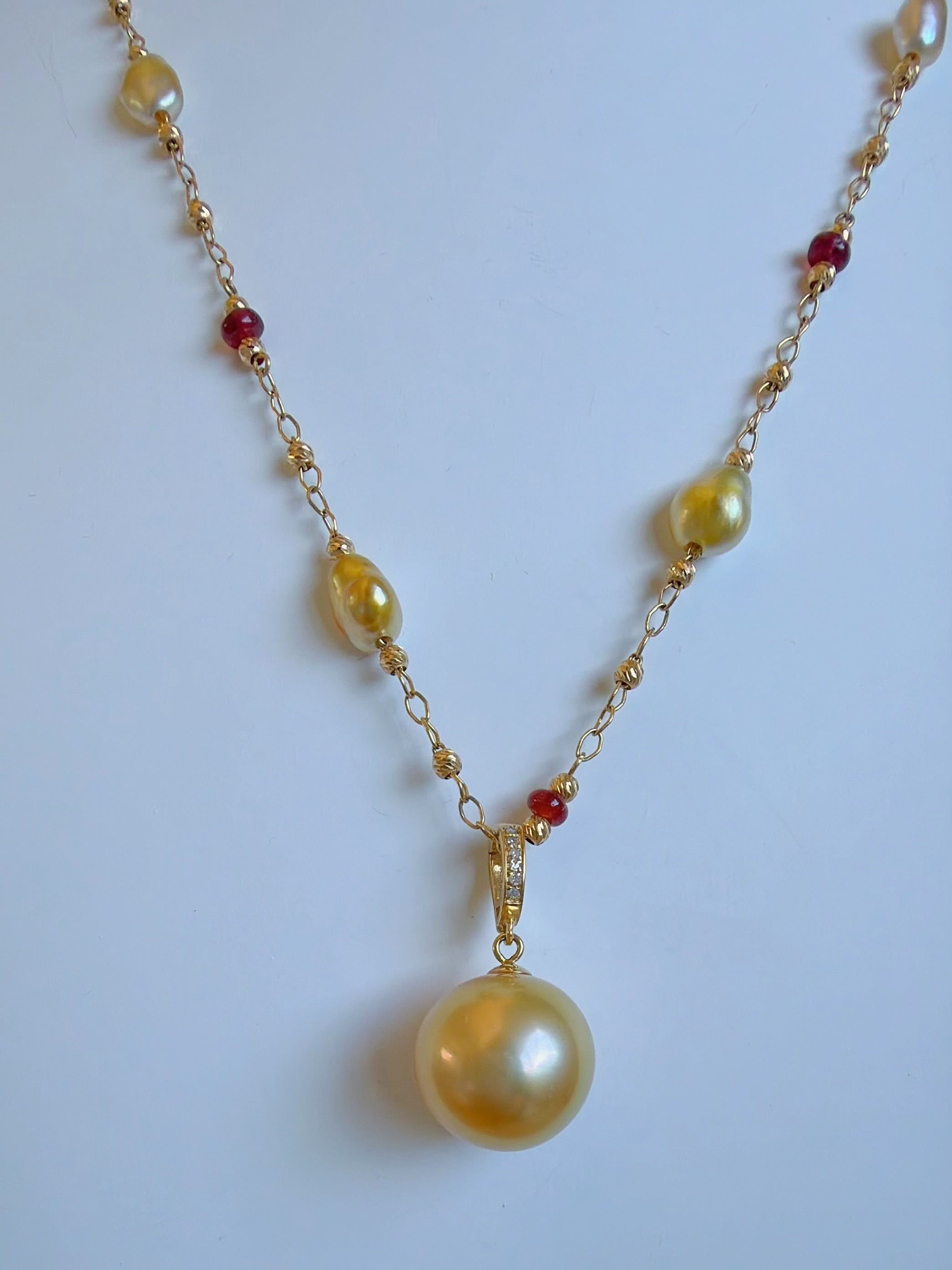 Gold pearl pendant necklace with red and yellow gemstone bead accents