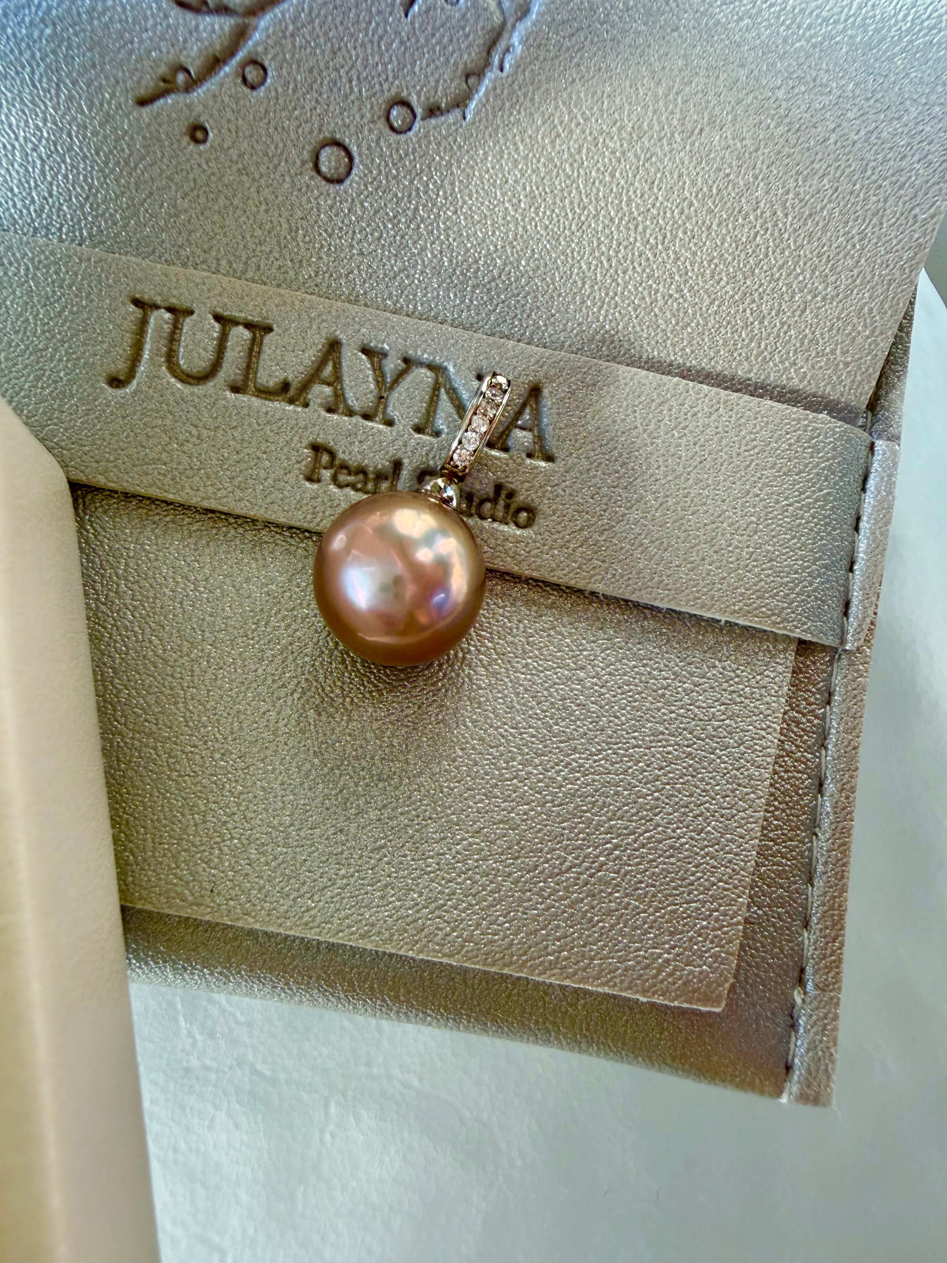 Gold-toned pearl pendant with small rhinestone accents and hanging loop