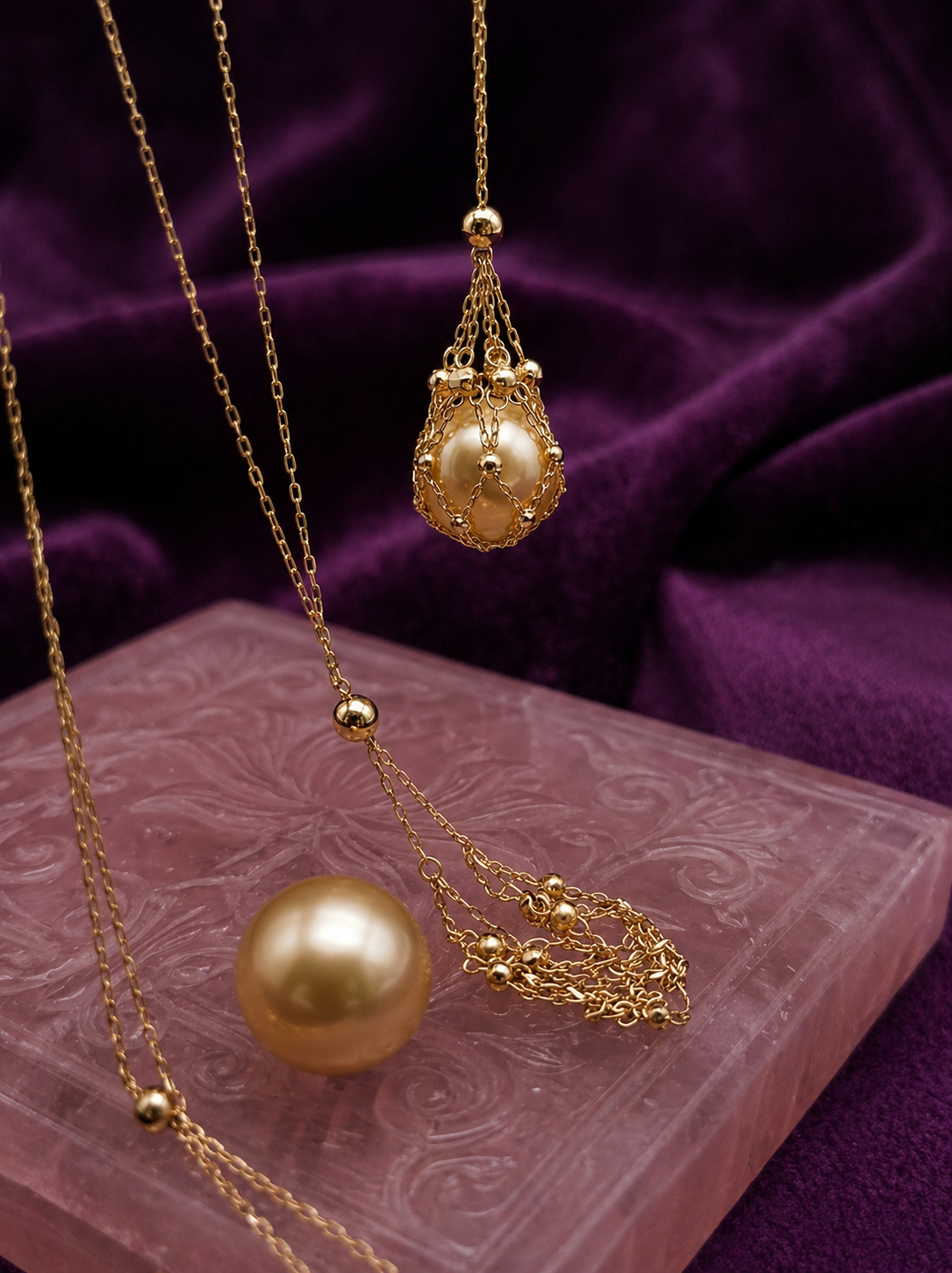 Gold tone net pendant necklace with teardrop charm and large golden pearl bead