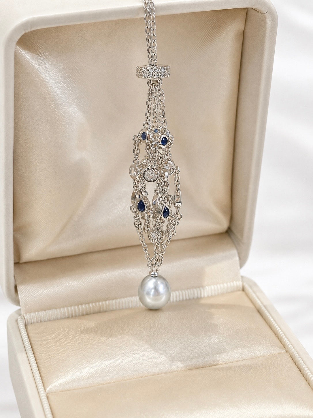 Silver tone openable net pendant necklace with blue accents and large pearl drop