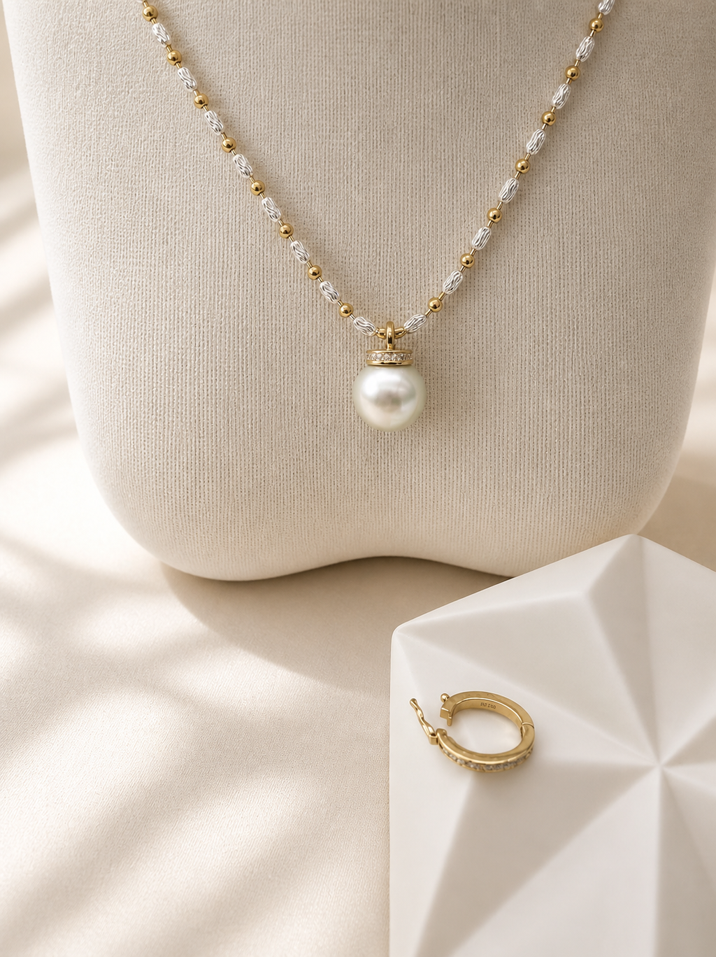 White pearl necklace with gold pendant holding a round South Sea pearl