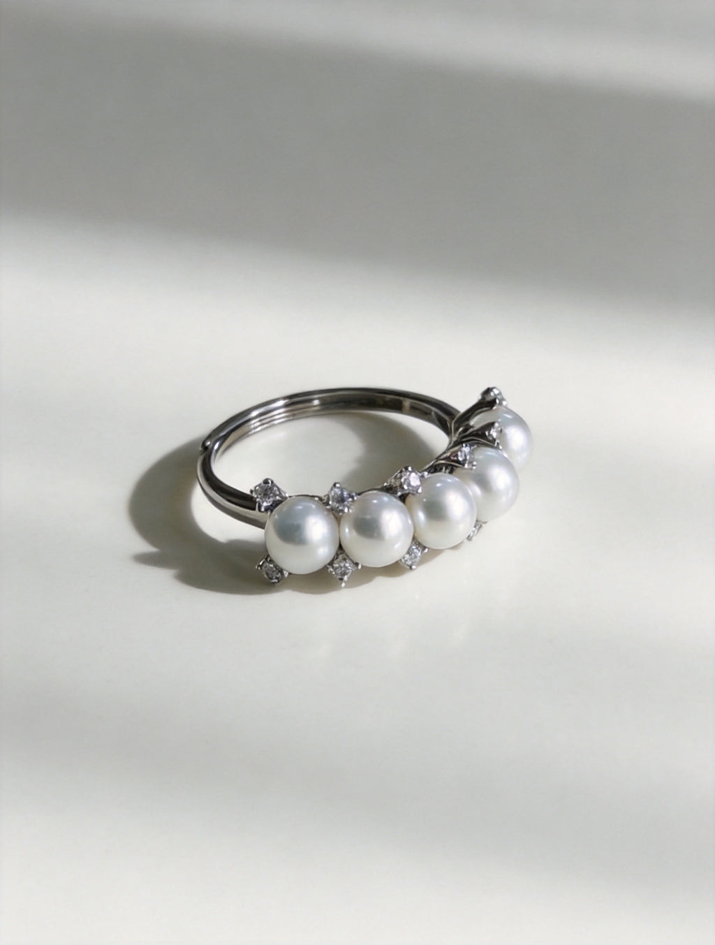 Adjustable silver ring with five white freshwater pearls and crystal top detail