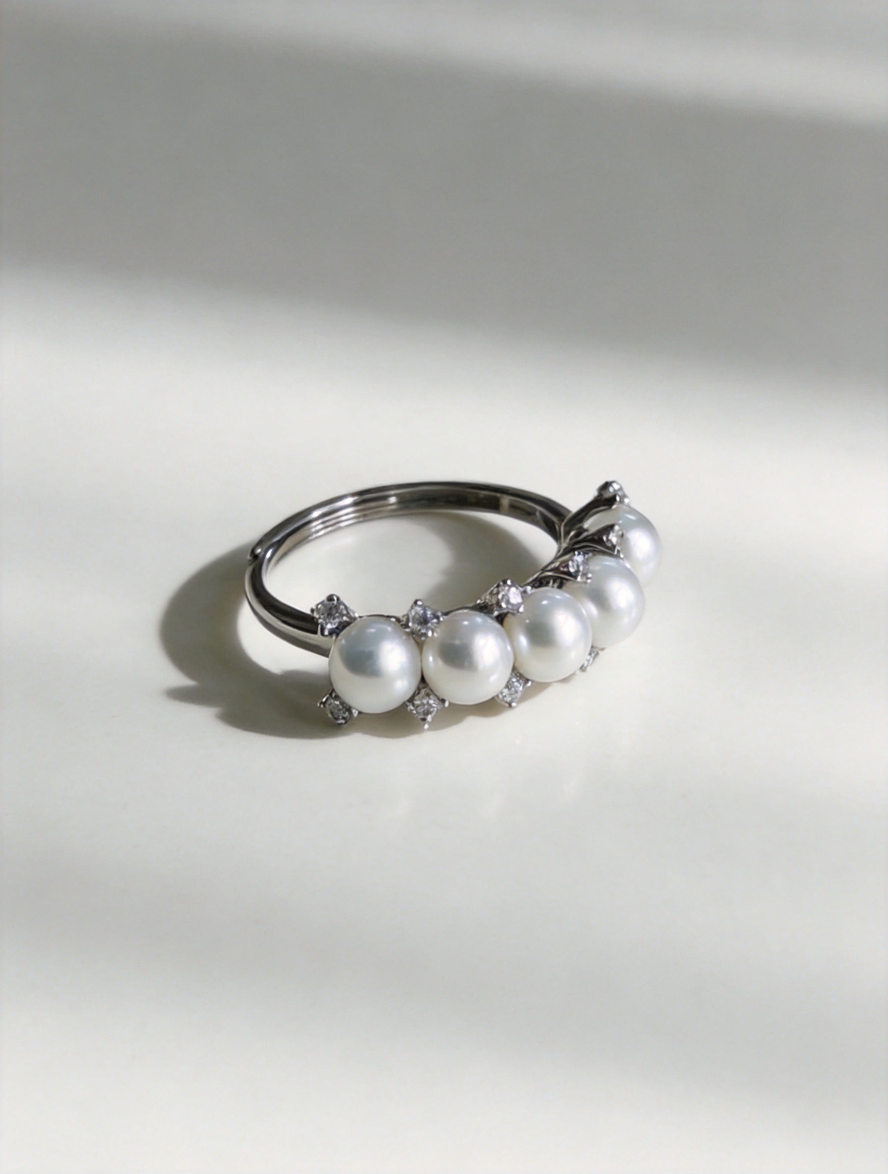 Adjustable silver ring with five white freshwater pearls and crystal top detail