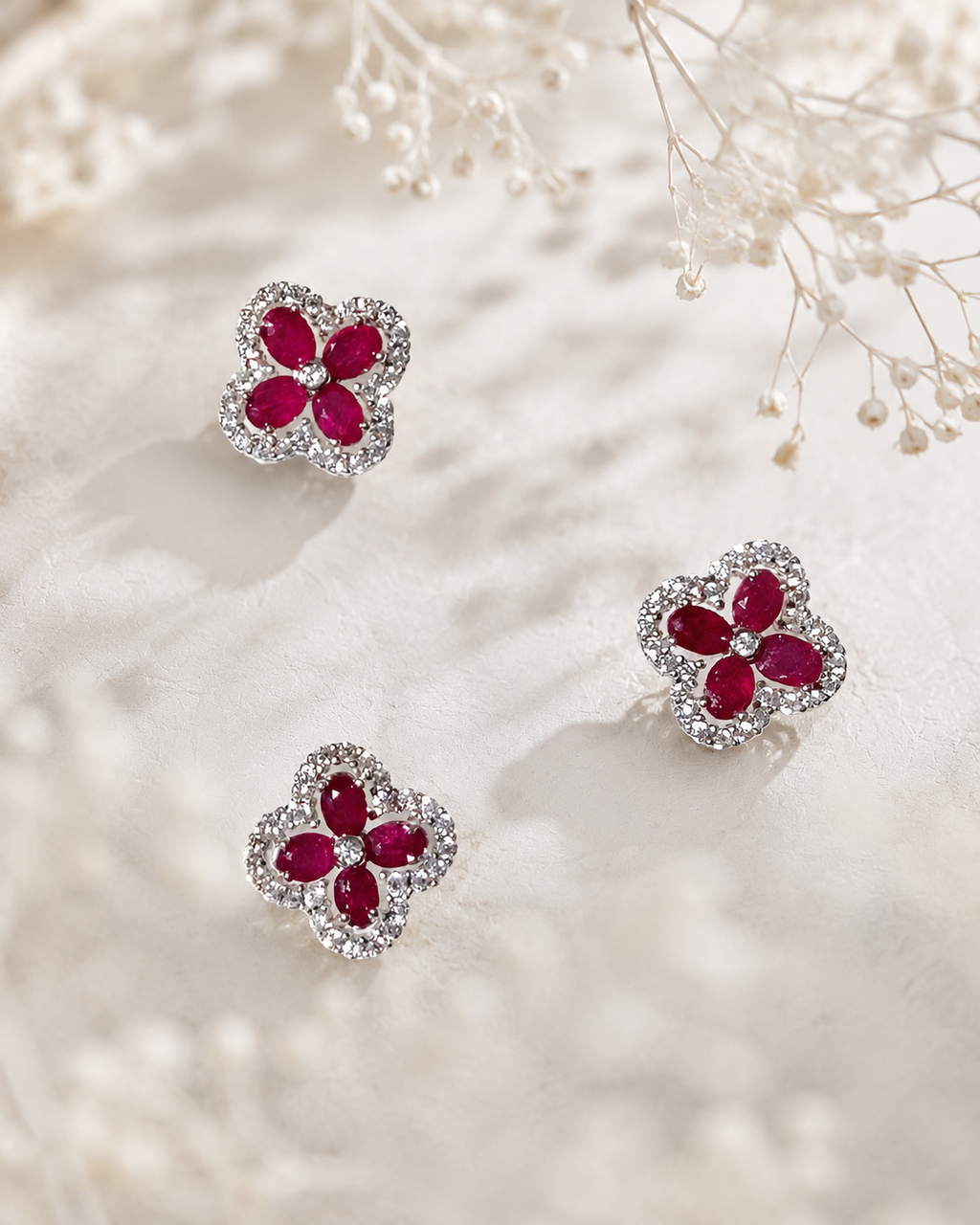 Four-leaf clover gemstone stud earrings in sterling silver with ruby-like stones
