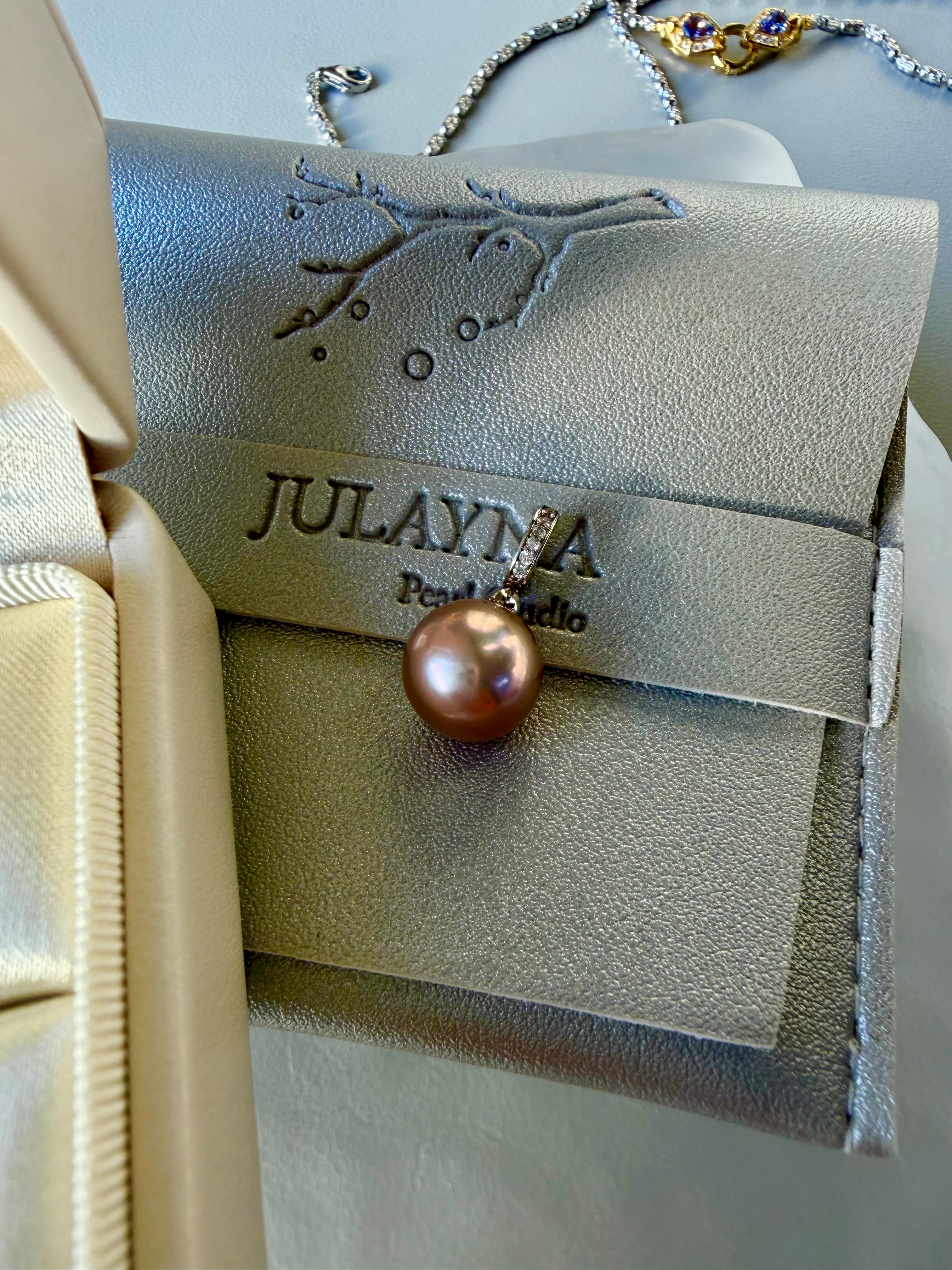 Gold-toned pearl pendant with rhinestone cap on necklace, hanging detail