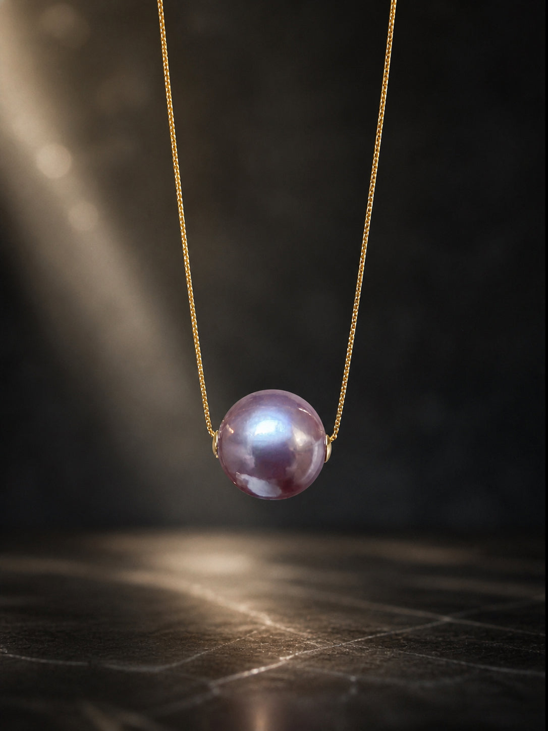 Gold necklace pendant with glossy purple pearl on a thin chain