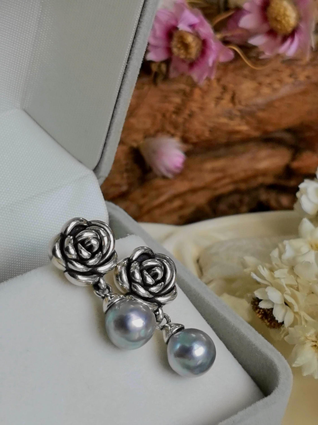 Rose drop earrings with silver rose tops and pearl beads inside a box