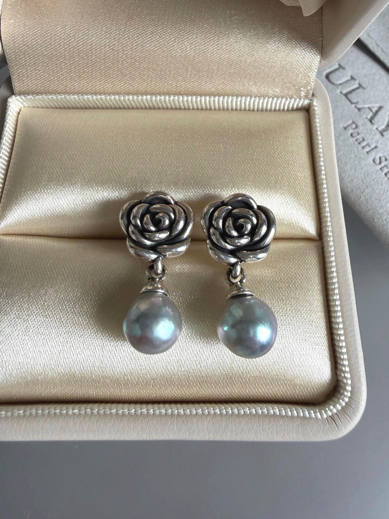 Sterling silver rose earrings with gray-blue pearls, front view in box
