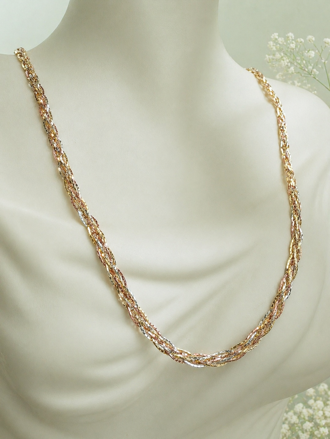 Three-tone gold braided necklace worn on a model, full necklace view