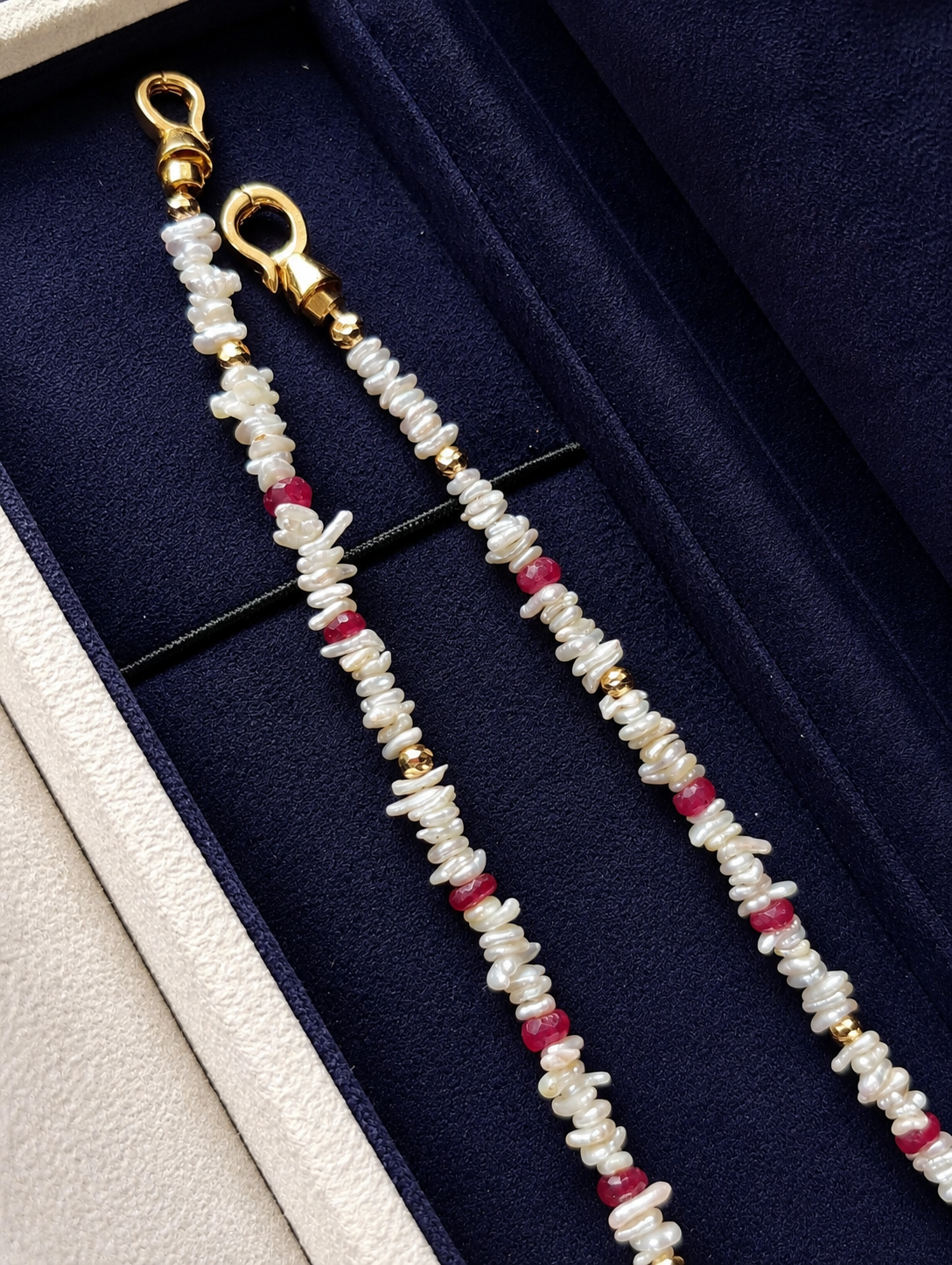 Pair of dangling strands from a keshi pearl necklace with red ruby bead accents
