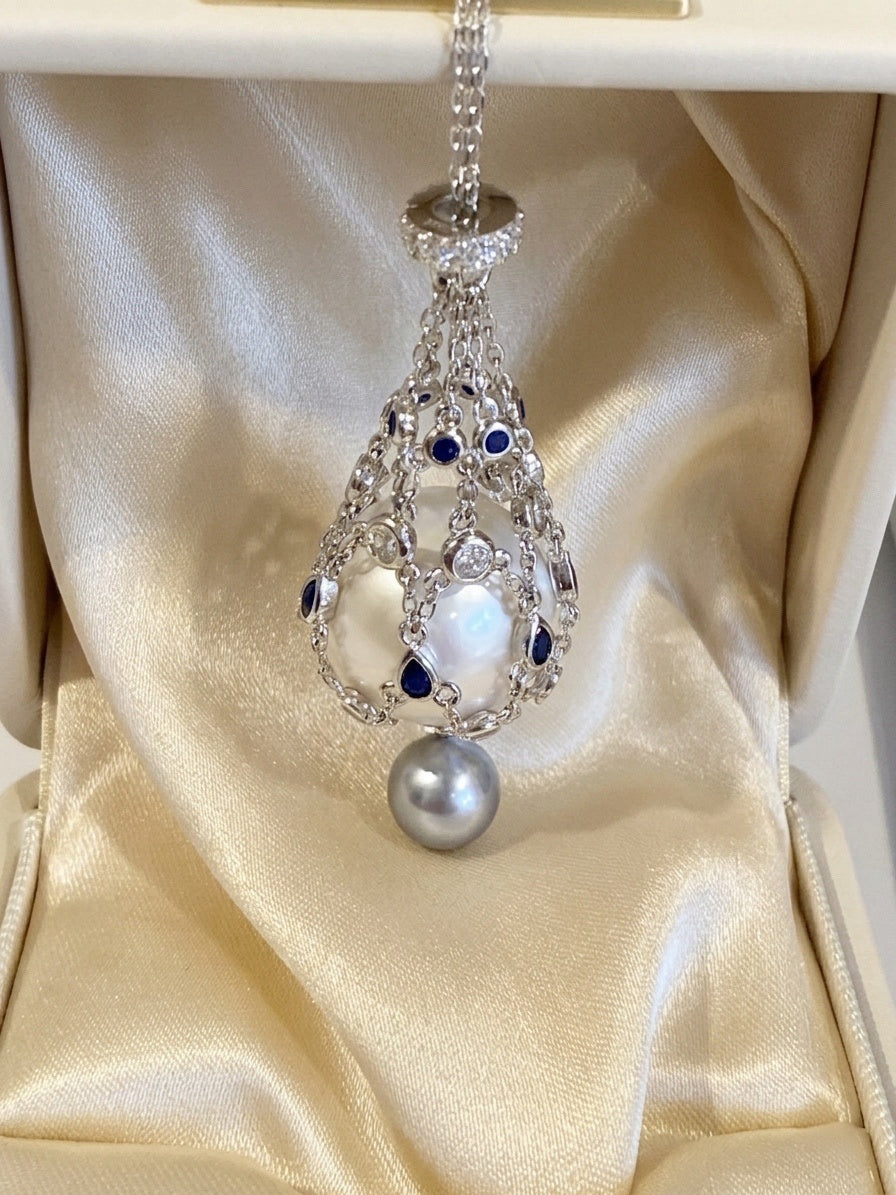 Openwork teardrop pendant necklace with blue stones and round pearl drop at center
