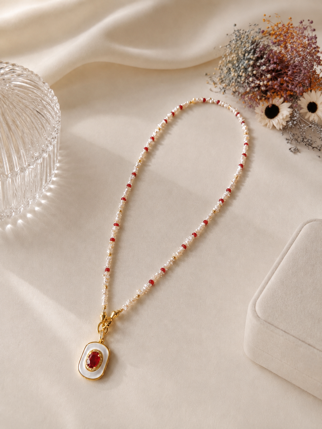 Beaded necklace with gold-tone mother-of-pearl oval pendant and ruby center stone