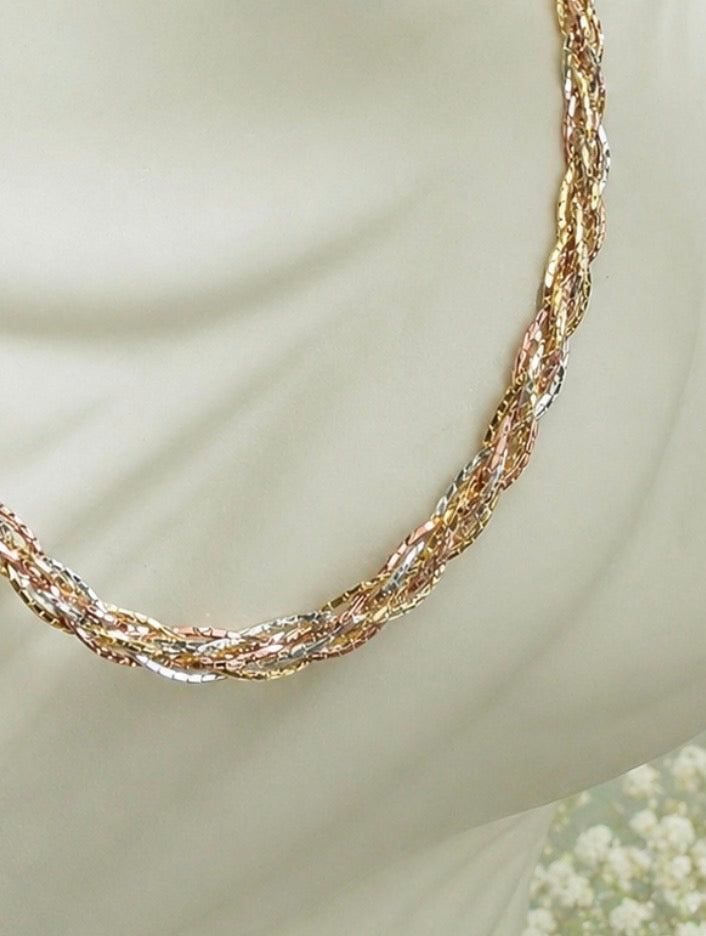 Three-tone gold braided necklace layered detail, textured chain close-up