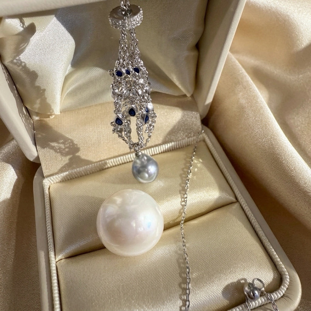 Pendant necklace with openwork teardrop frame, blue stones, and round pearl drop