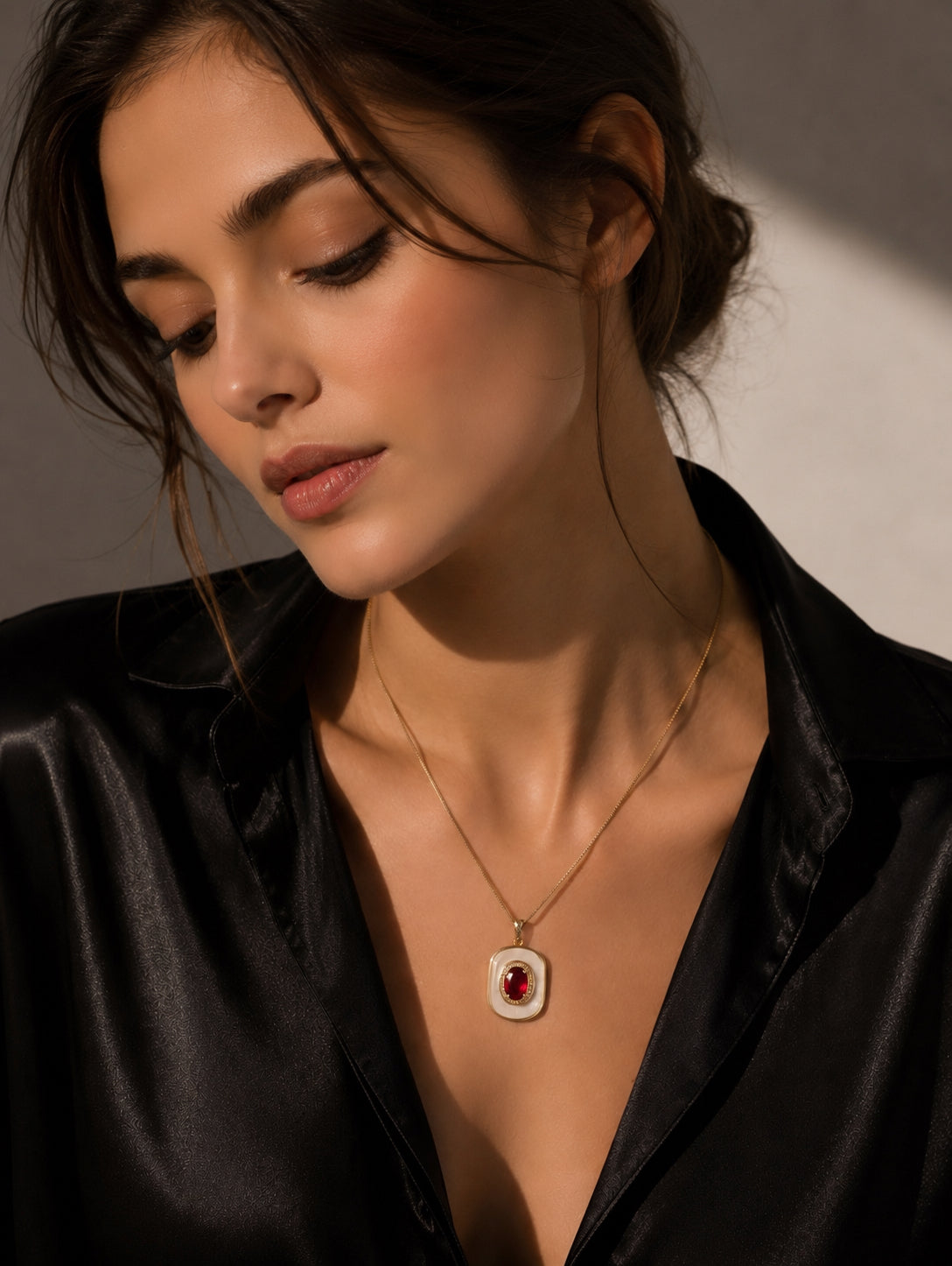 Gold-tone pendant necklace with mother-of-pearl oval and ruby center stone