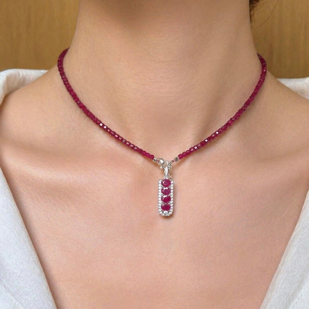 Ruby bead necklace with silver-toned connector and central red gemstone drop