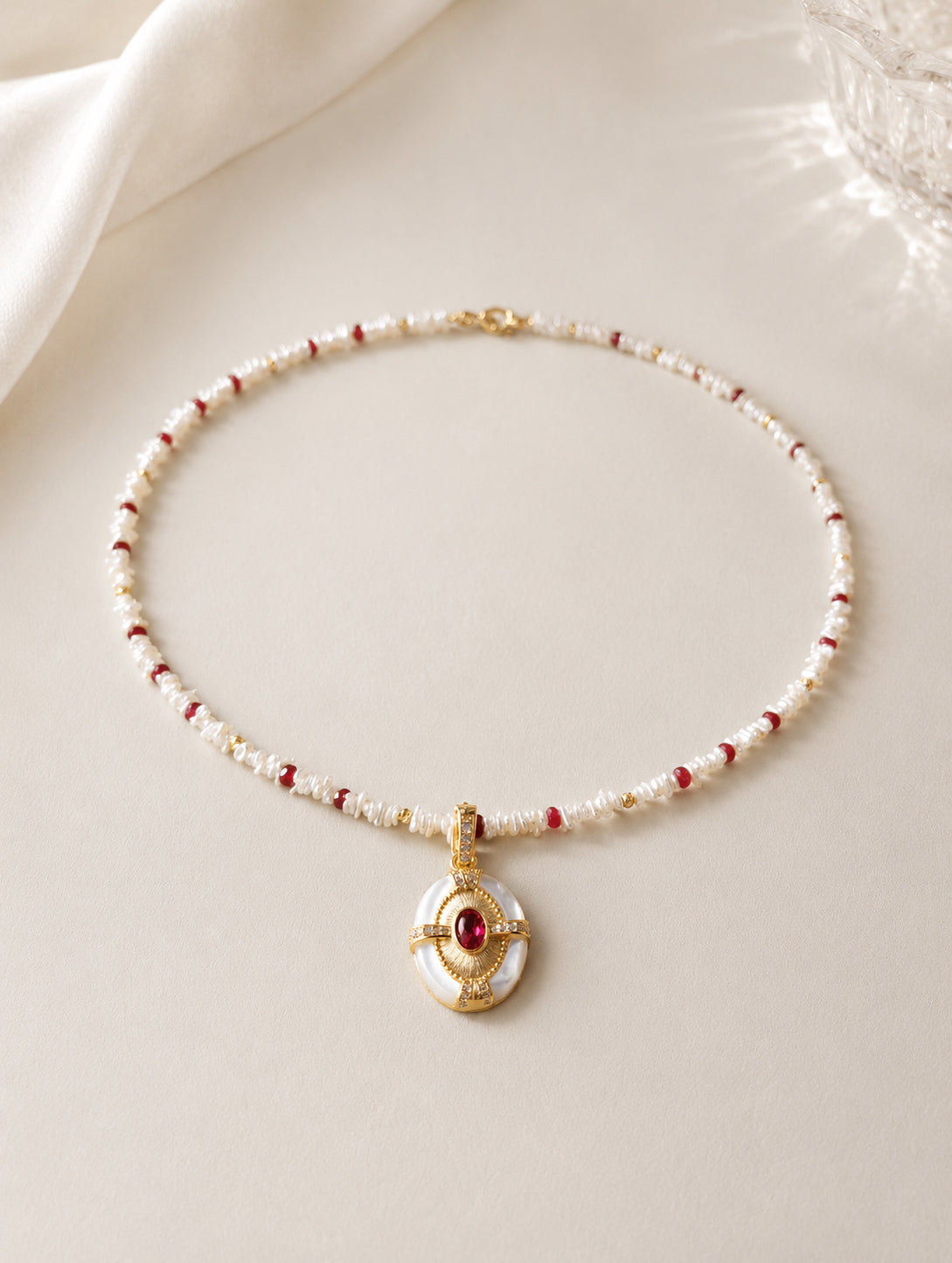 Gold keshi pearl necklace with ruby red accents and oval ruby pendant