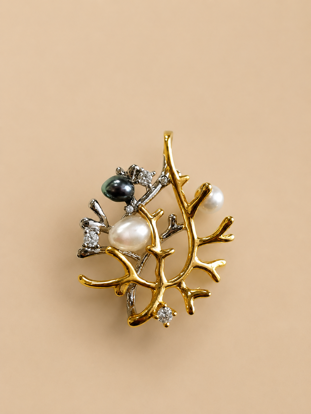 Silver necklace pendant with branch design, pearl drop, and crystal accents.