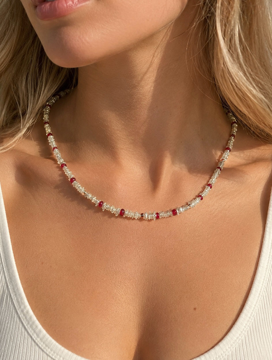 Keshi pearl necklace with red ruby bead accents on a model’s neckline