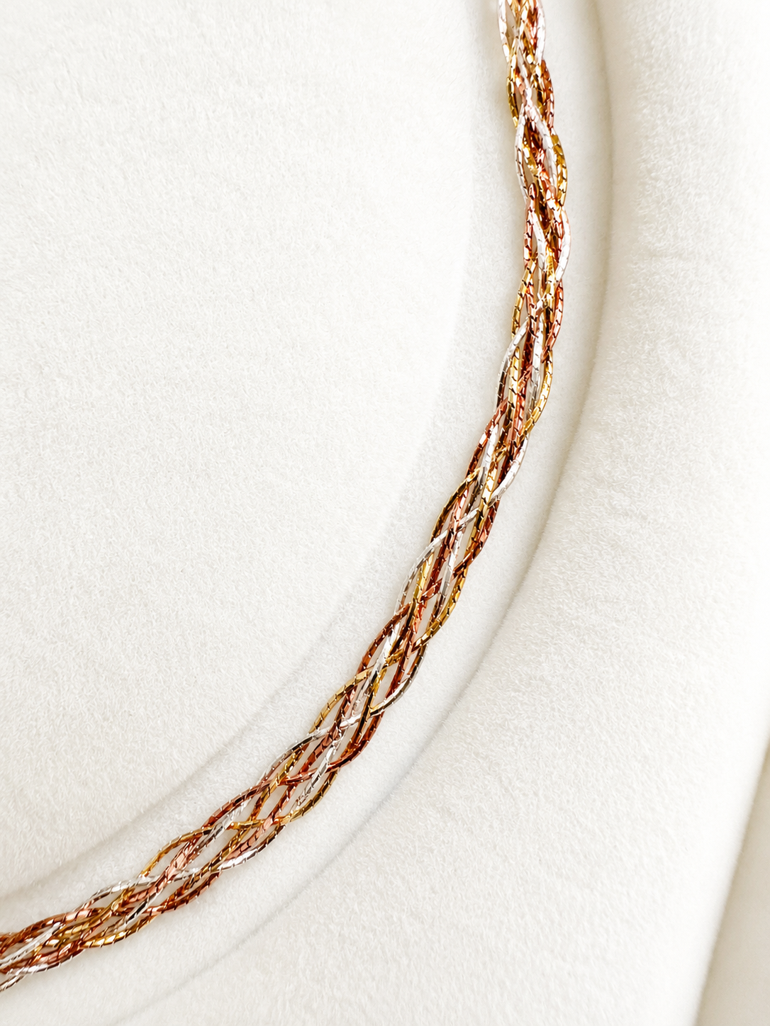 Three-tone braided gold necklace close-up of twisted links