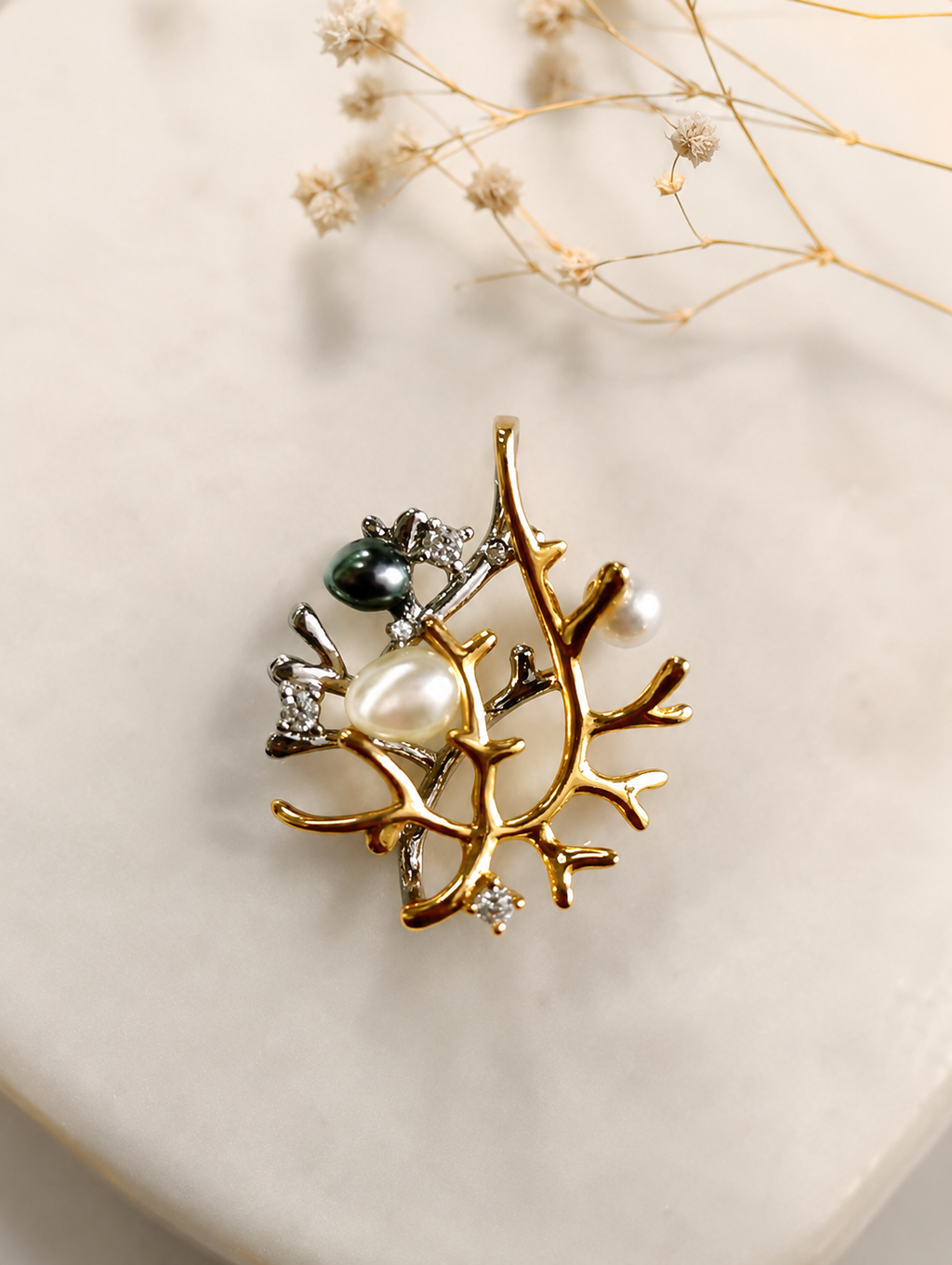 Starburst pendant with pearl, dark bead, and rhinestone accents in gold-tone and silver-tone