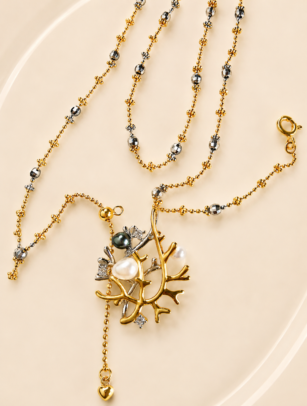 Silver necklace set with multiple beaded chain strands and branch pendant with pearl drop.