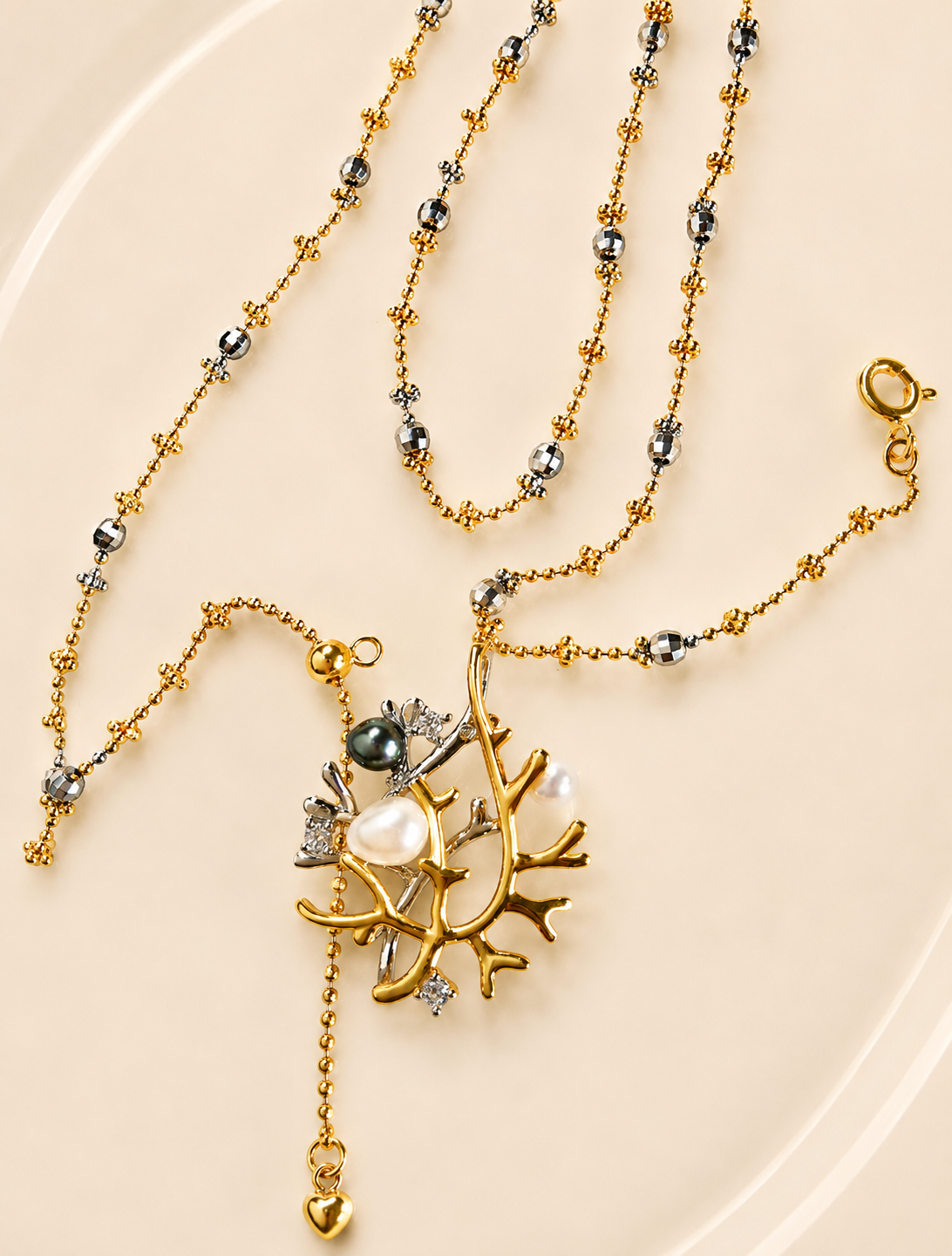 Silver necklace set with multiple beaded chain strands and branch pendant with pearl drop.