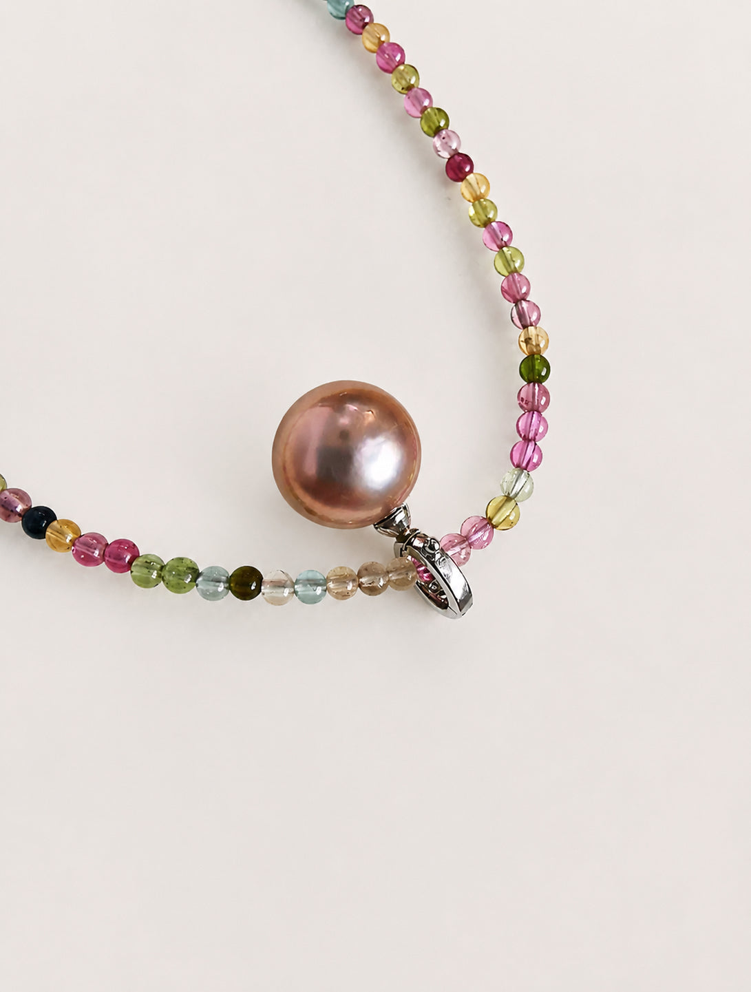 Rainbow bead necklace with pink pearl centerpiece and small silver clasp ring