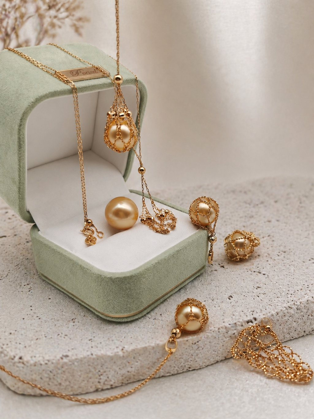 Gold-toned treasure net pendant necklace with teardrop charm and pearl-like accents