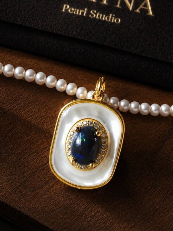 Pearl necklace with blue opal-style pendant in white bezel, gold-tone bail