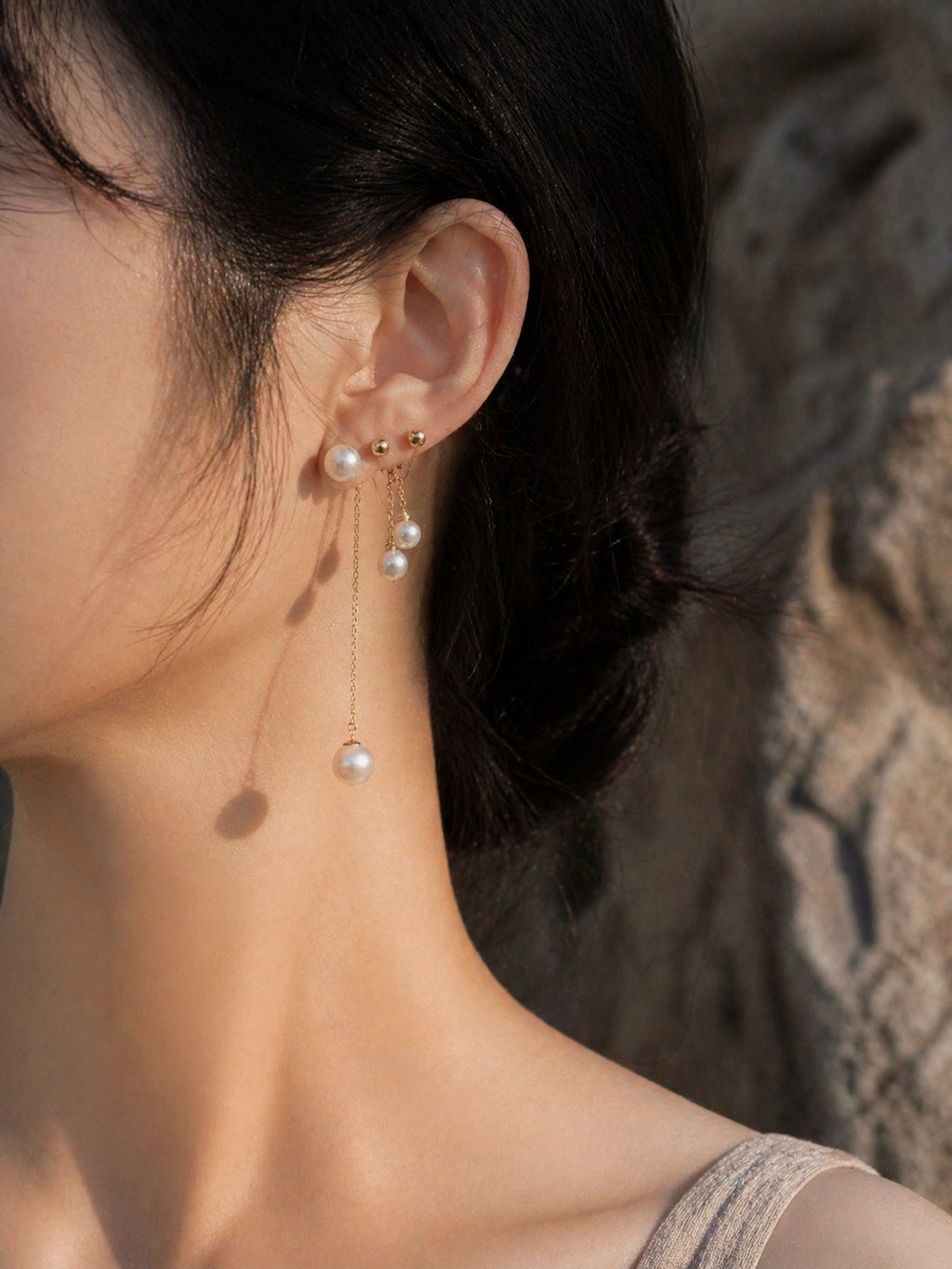 Long threader pearl earrings with gold-tone chain and dangling pearl on ear