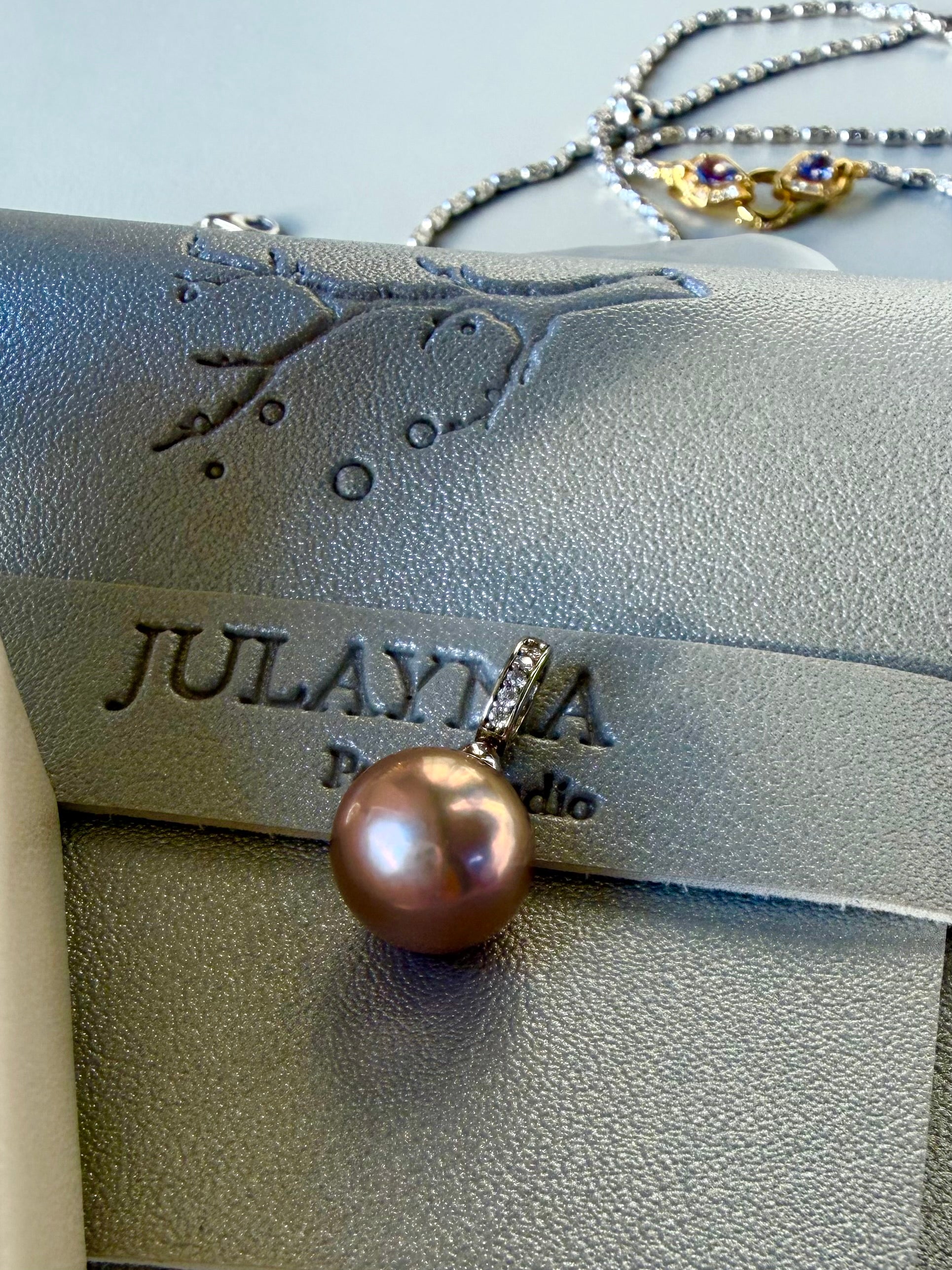 Pearl drop pendant with rhinestone top and gold-toned hoop, side view
