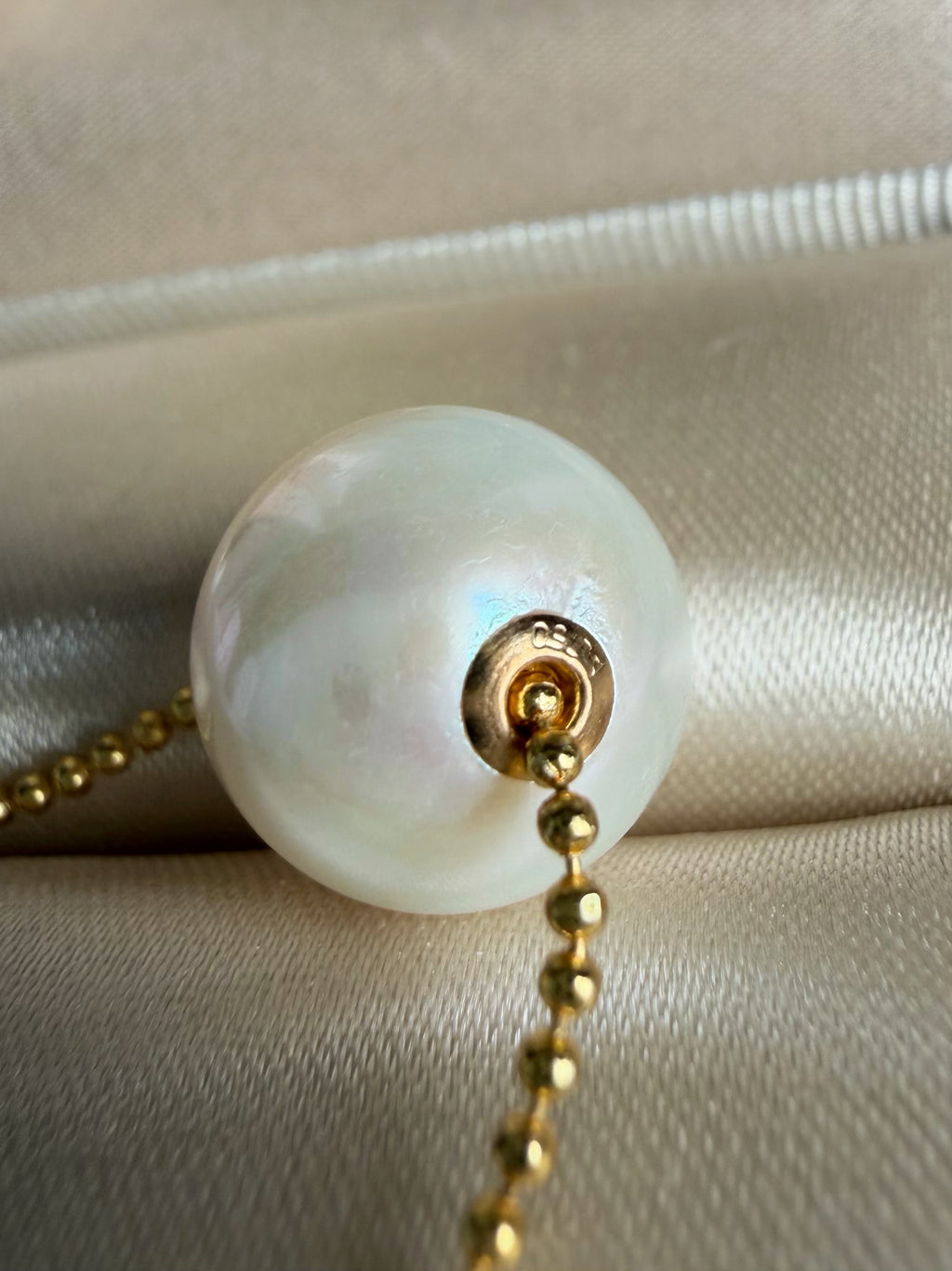 White freshwater pearl pendant detail with gold-tone ring and chain