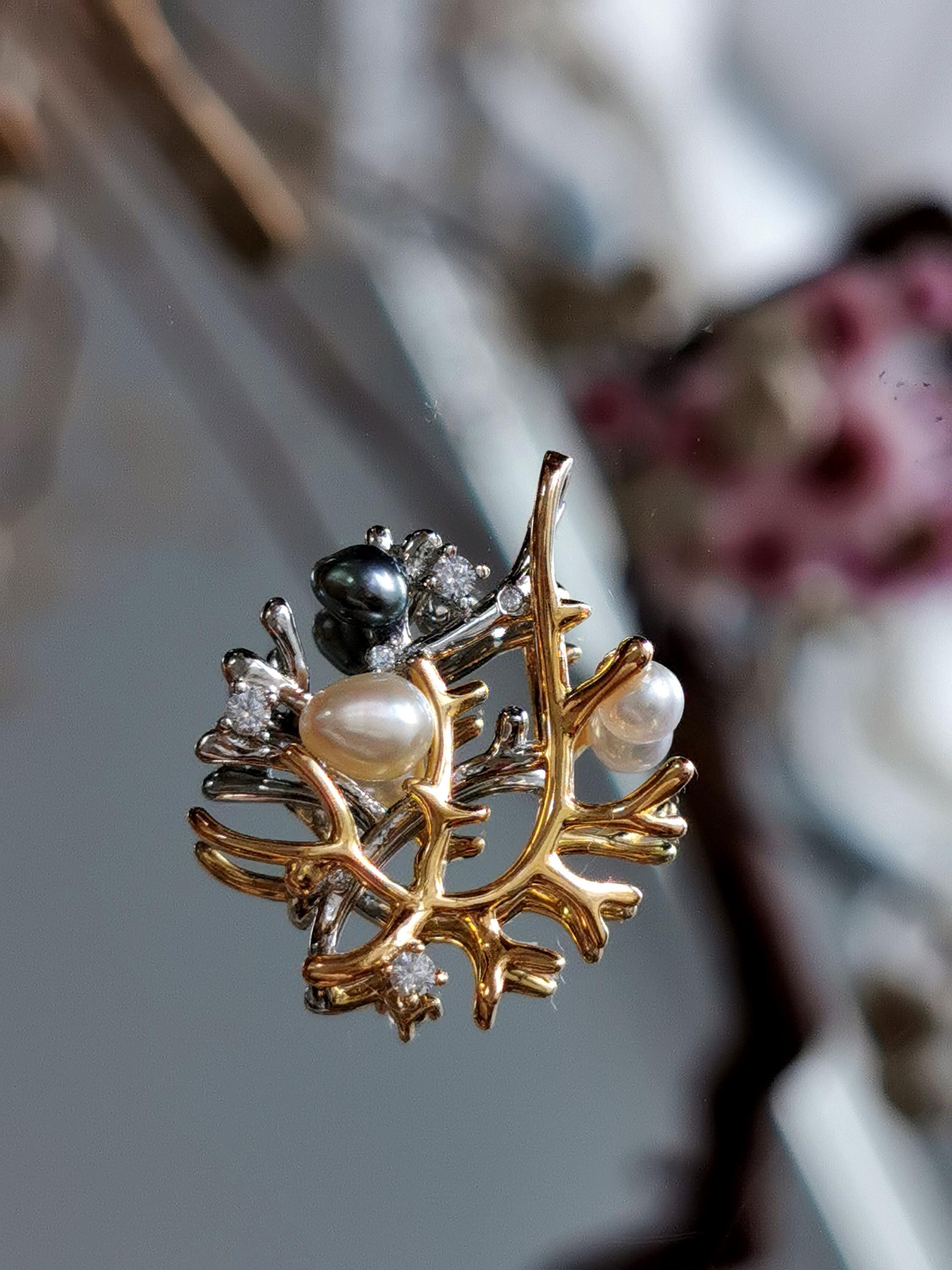 Silver necklace pendant close-up with branch motif, pearls, and crystal embellishments.