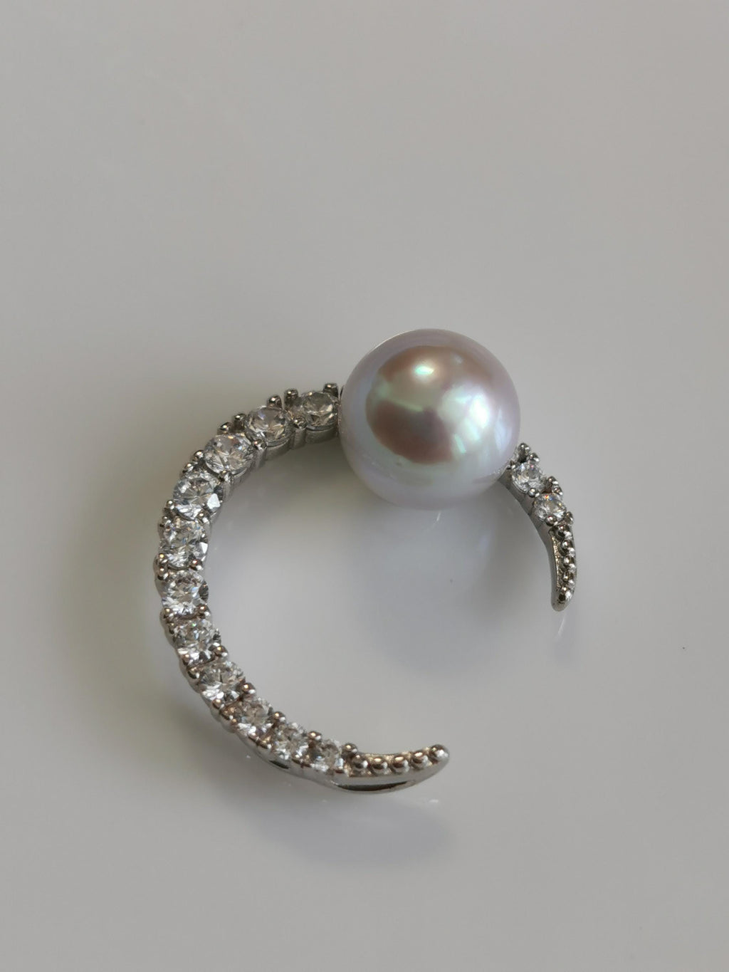 Silver crescent pendant with round pearl and pavé stone detailing