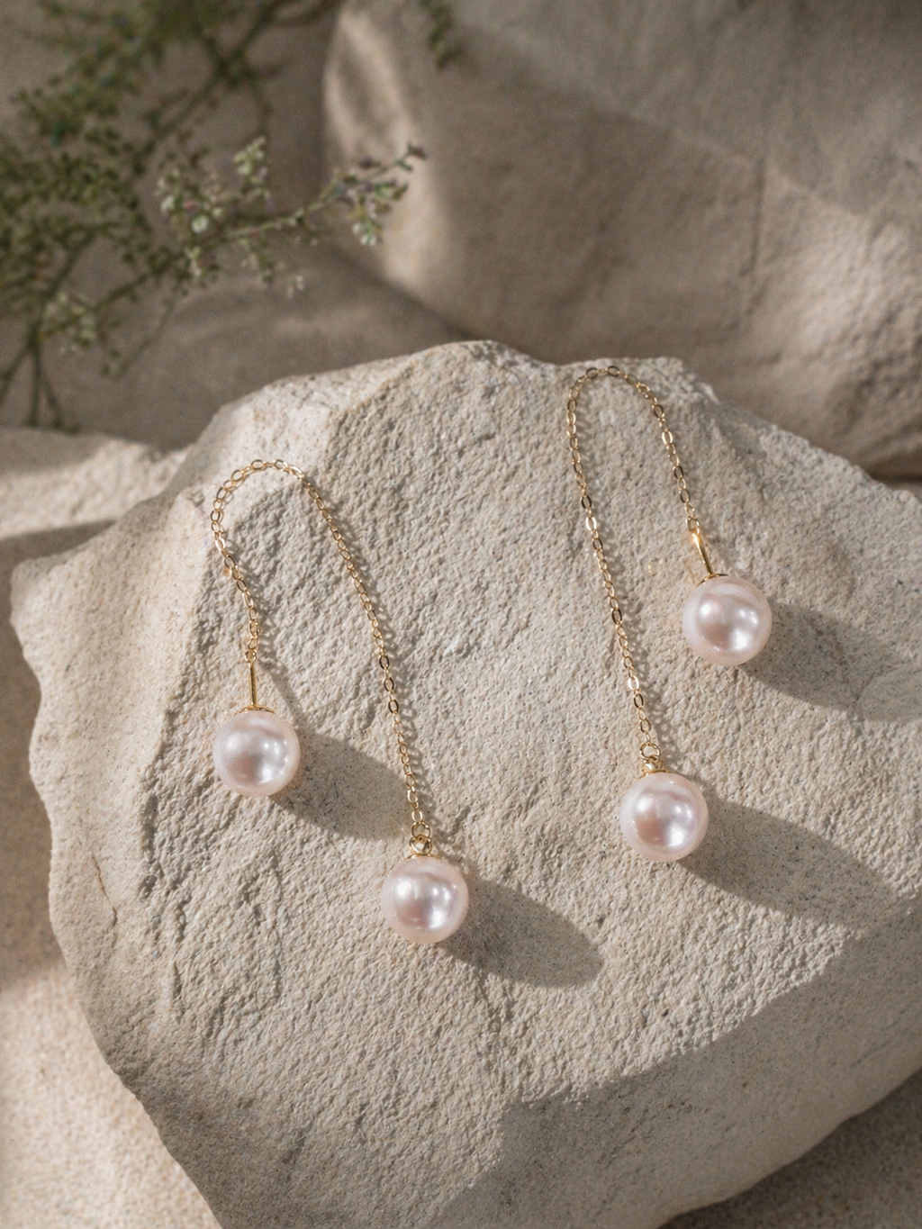 Long threader pearl earrings with gold-tone chains and multiple rounded dangling pearls