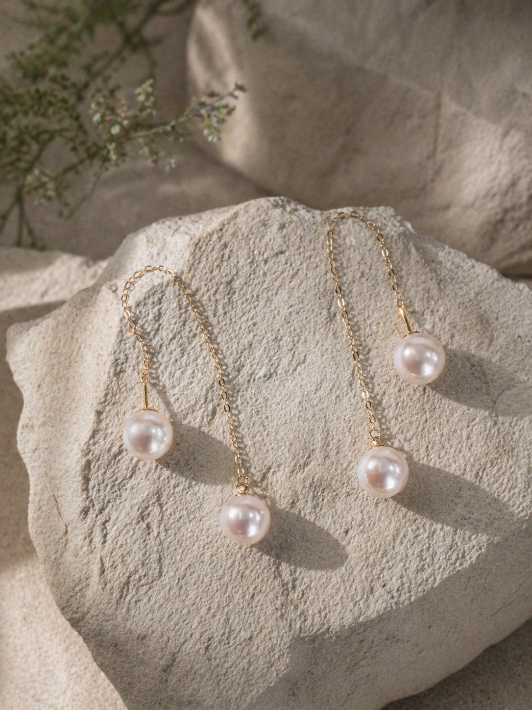 Long threader pearl earrings with gold-tone chains and multiple rounded dangling pearls