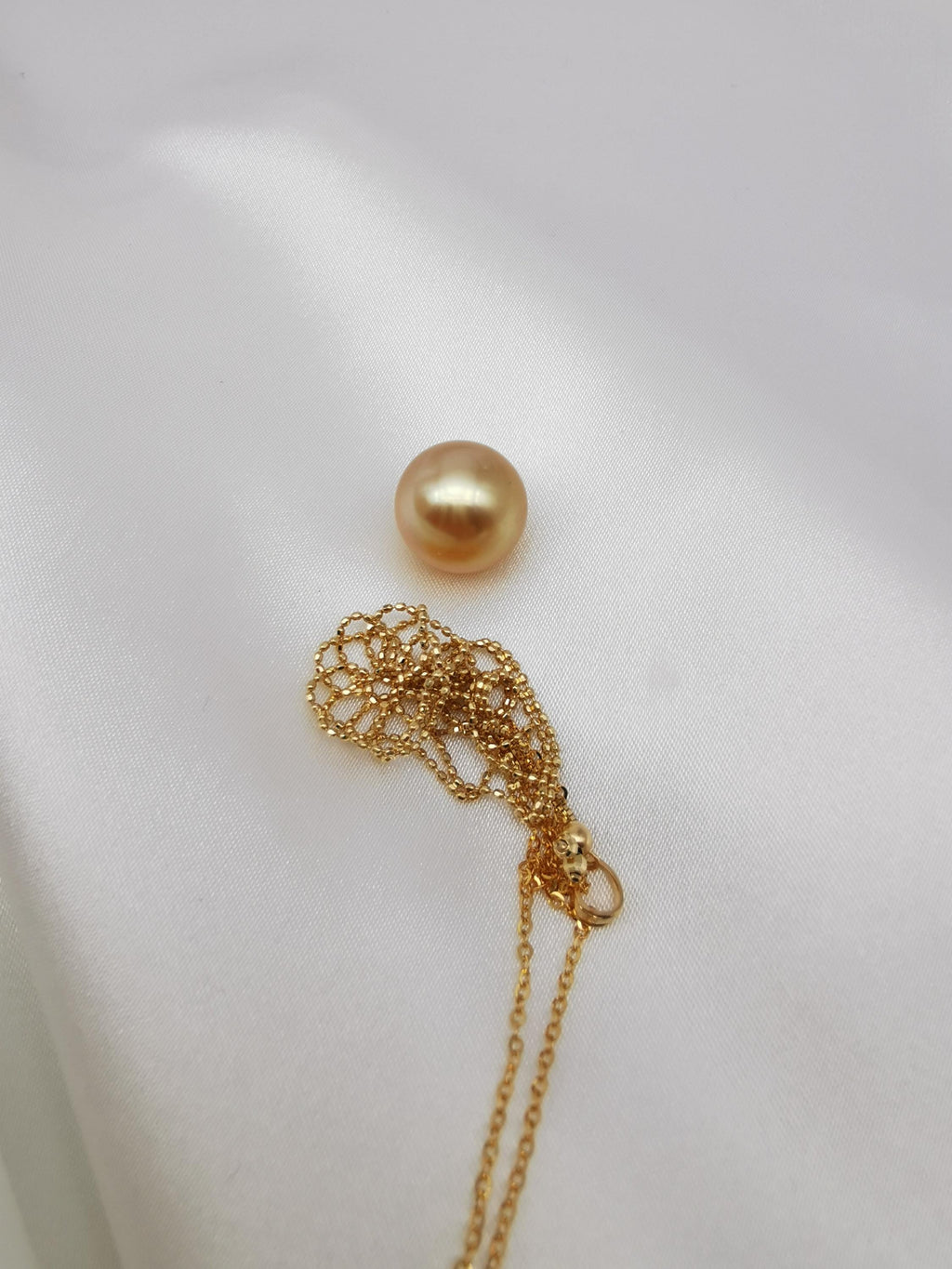 18K solid gold net pouch pendant with golden pearl on gold chain close-up