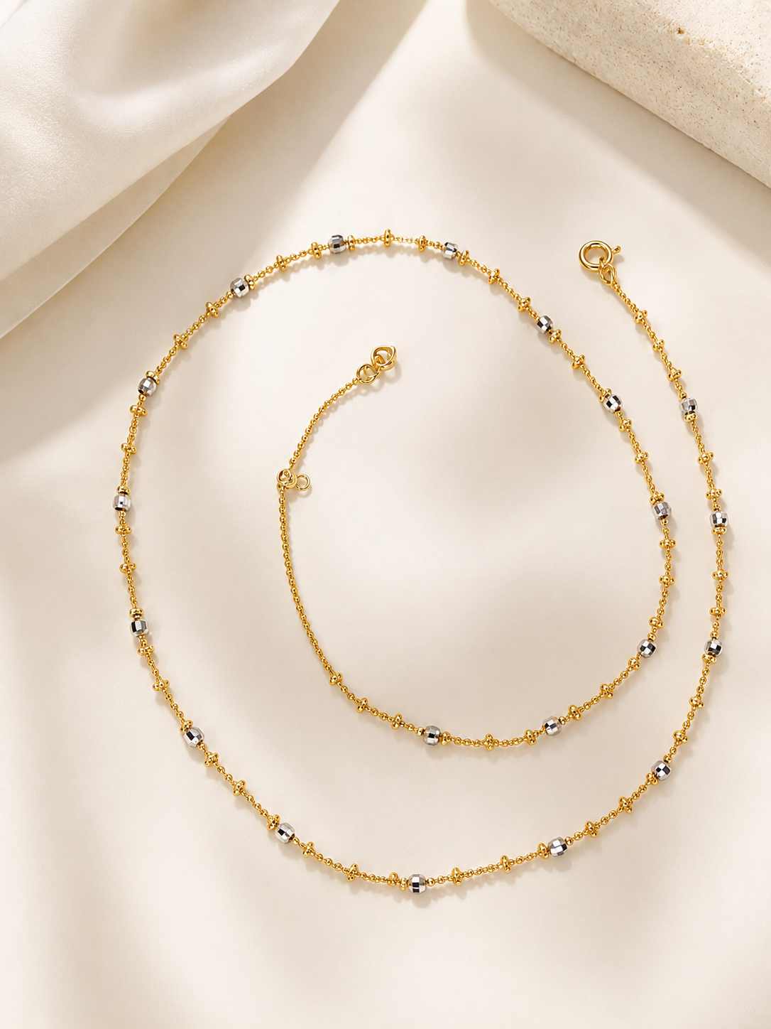 Silver necklace with beaded chain strands and small round accents, with clasp detail.