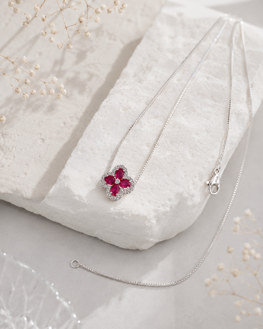 Sterling silver clover pendant on a delicate chain with a ruby-like center stone