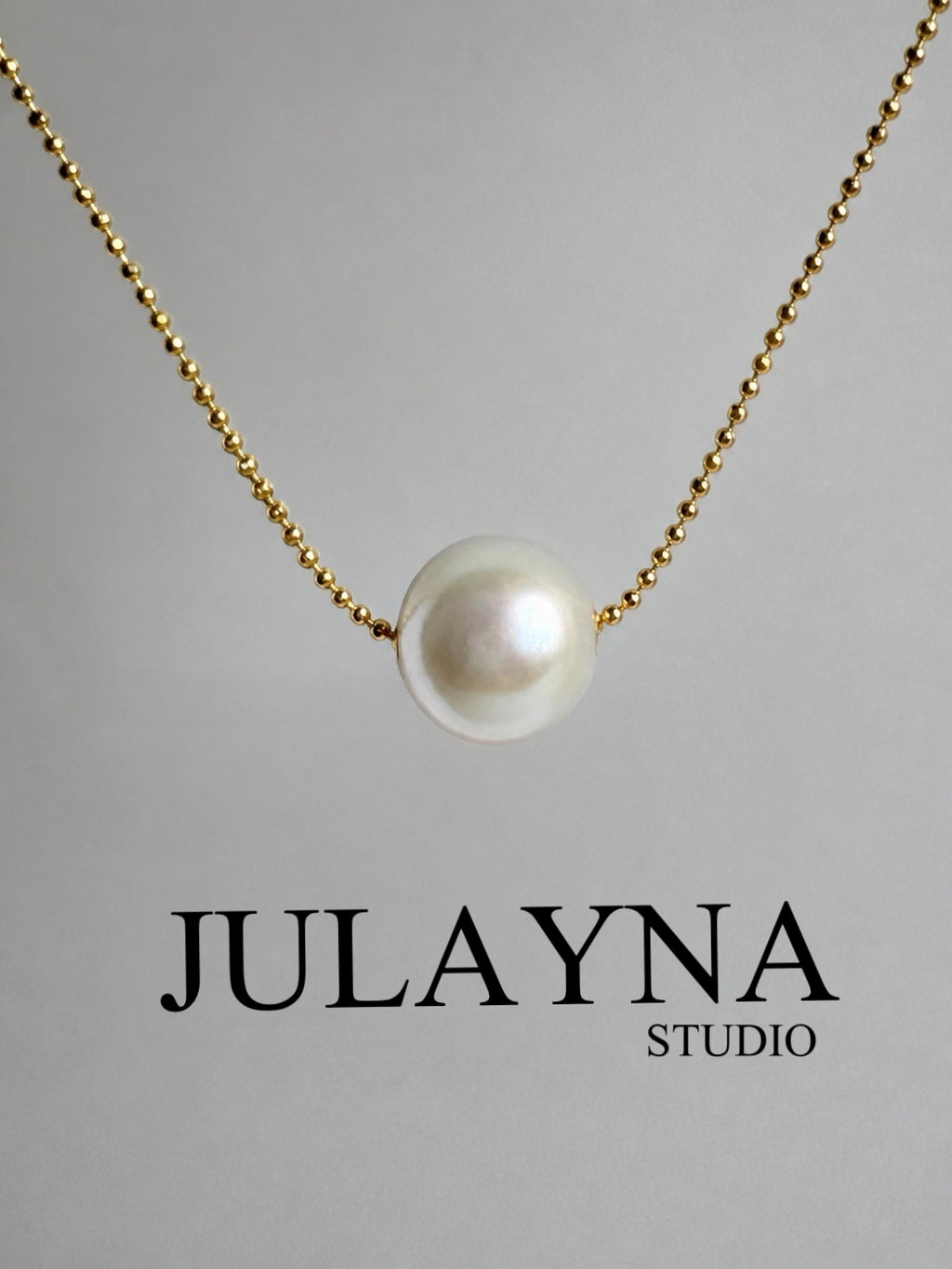 Gold-tone chain necklace with white freshwater pearl pendant, centered view