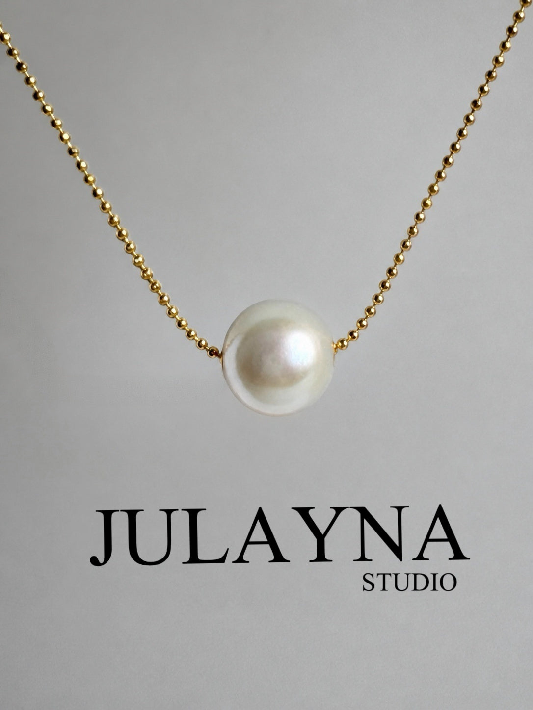 Gold-tone chain necklace with white freshwater pearl pendant, centered view