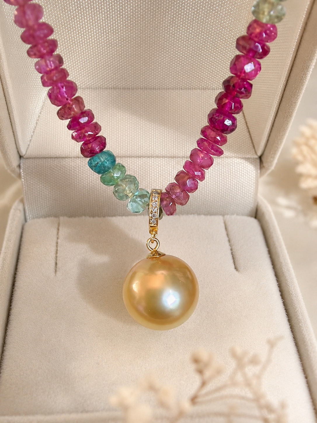 Gold pearl pendant on multicolor bead necklace with pink and teal faceted stones