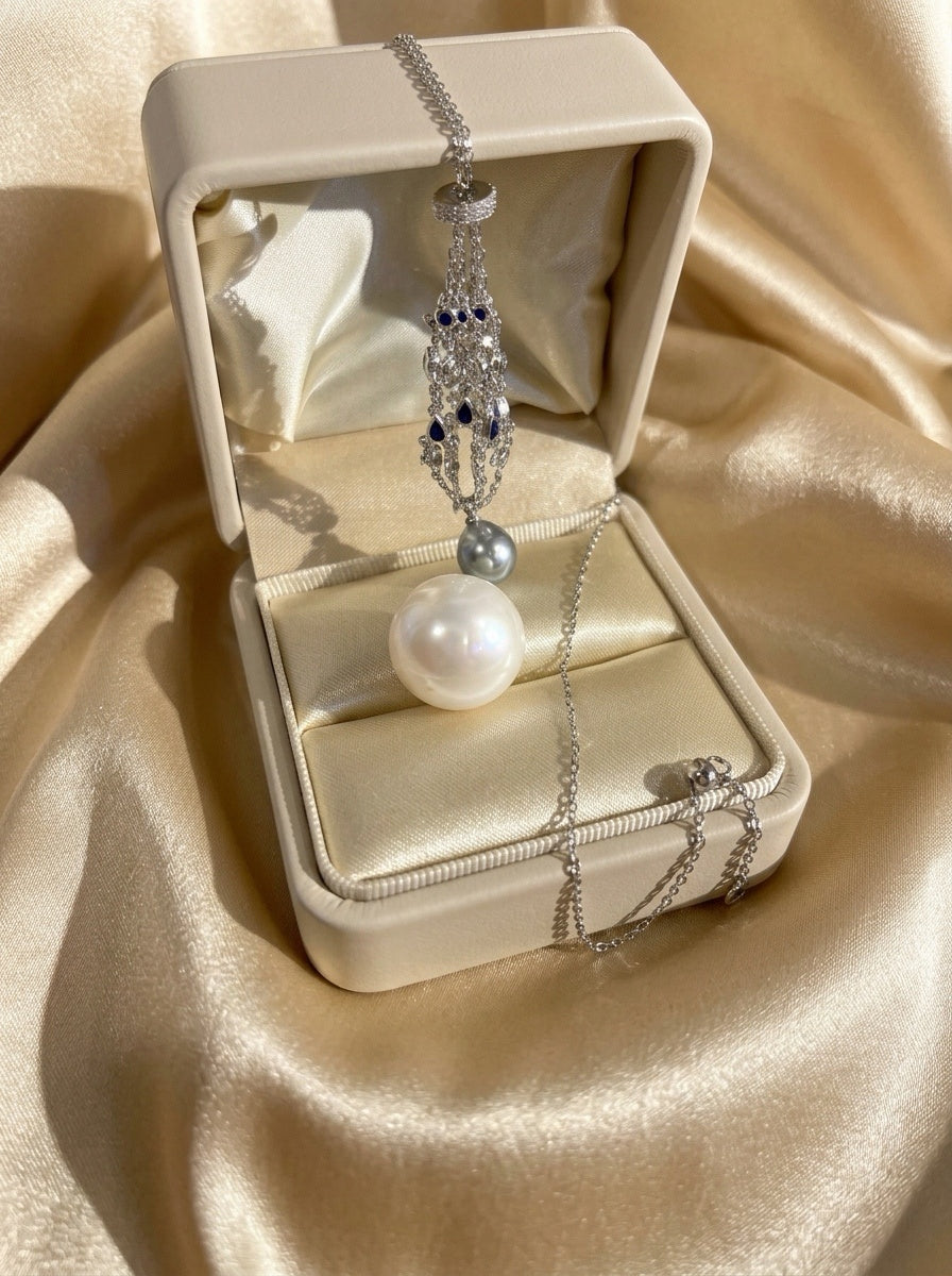 Pendant necklace with openwork teardrop pendant, blue accents, and round pearl drop