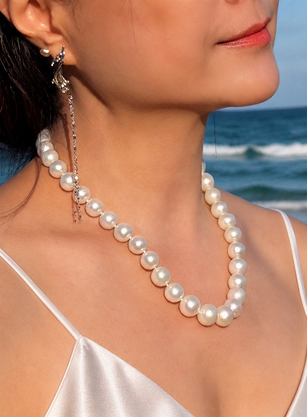 Pearl necklace worn at the neckline with a gold-tone clasp detail