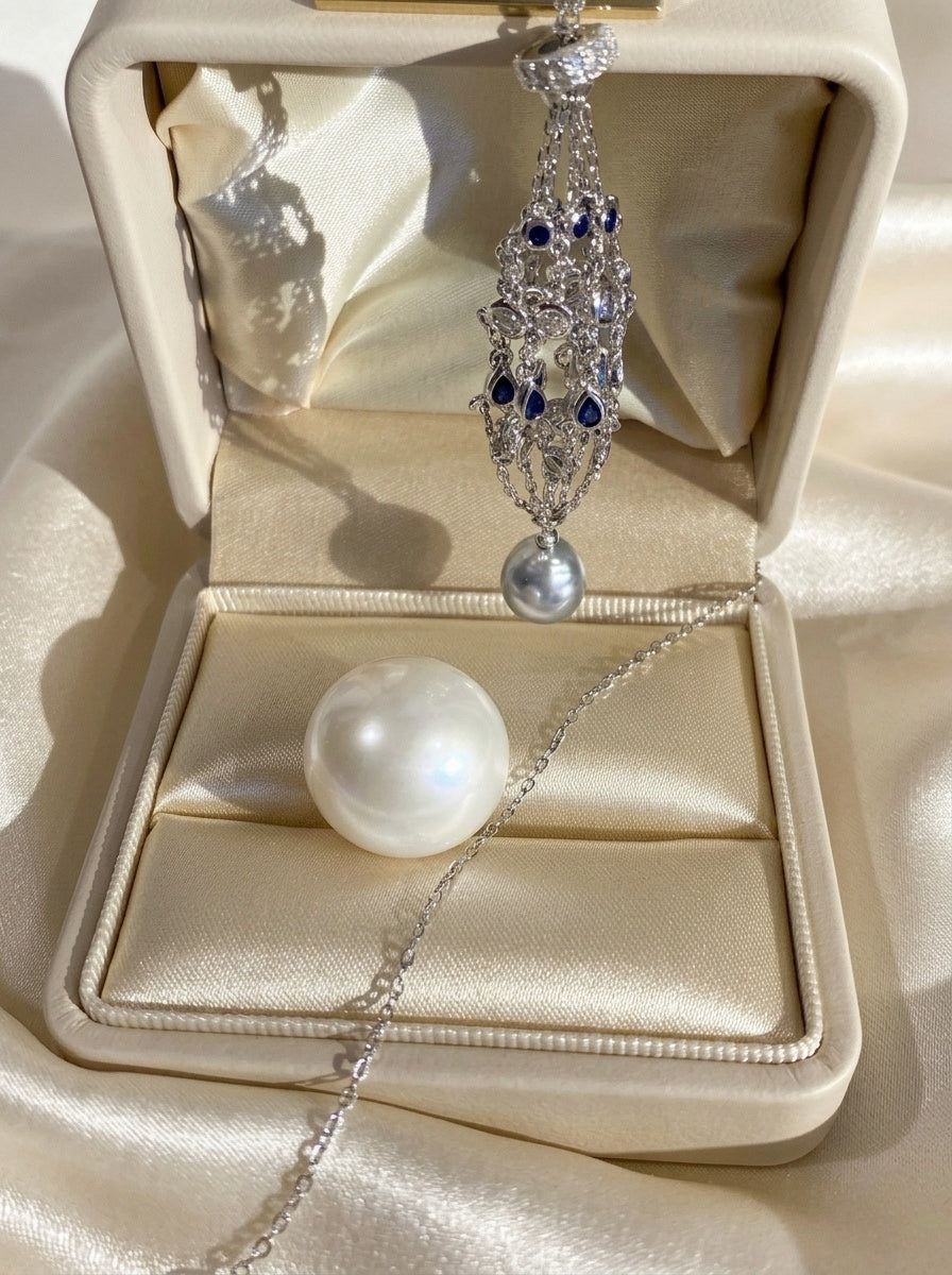 Pendant necklace with openwork silver-toned teardrop pendant and blue stone cluster
