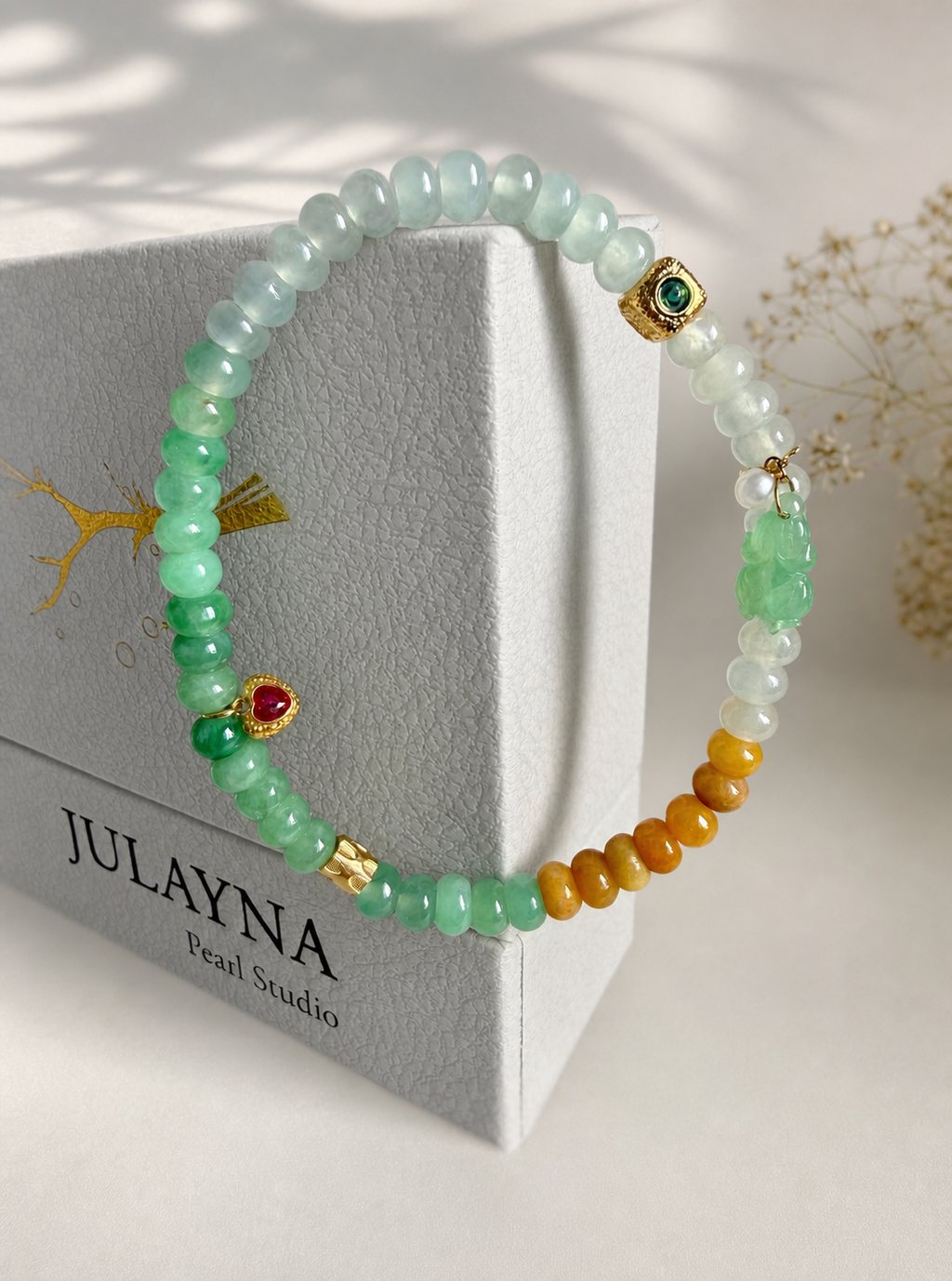 Jadeite beaded bracelet with mint green beads, gold clasp charm, and white tassel bead