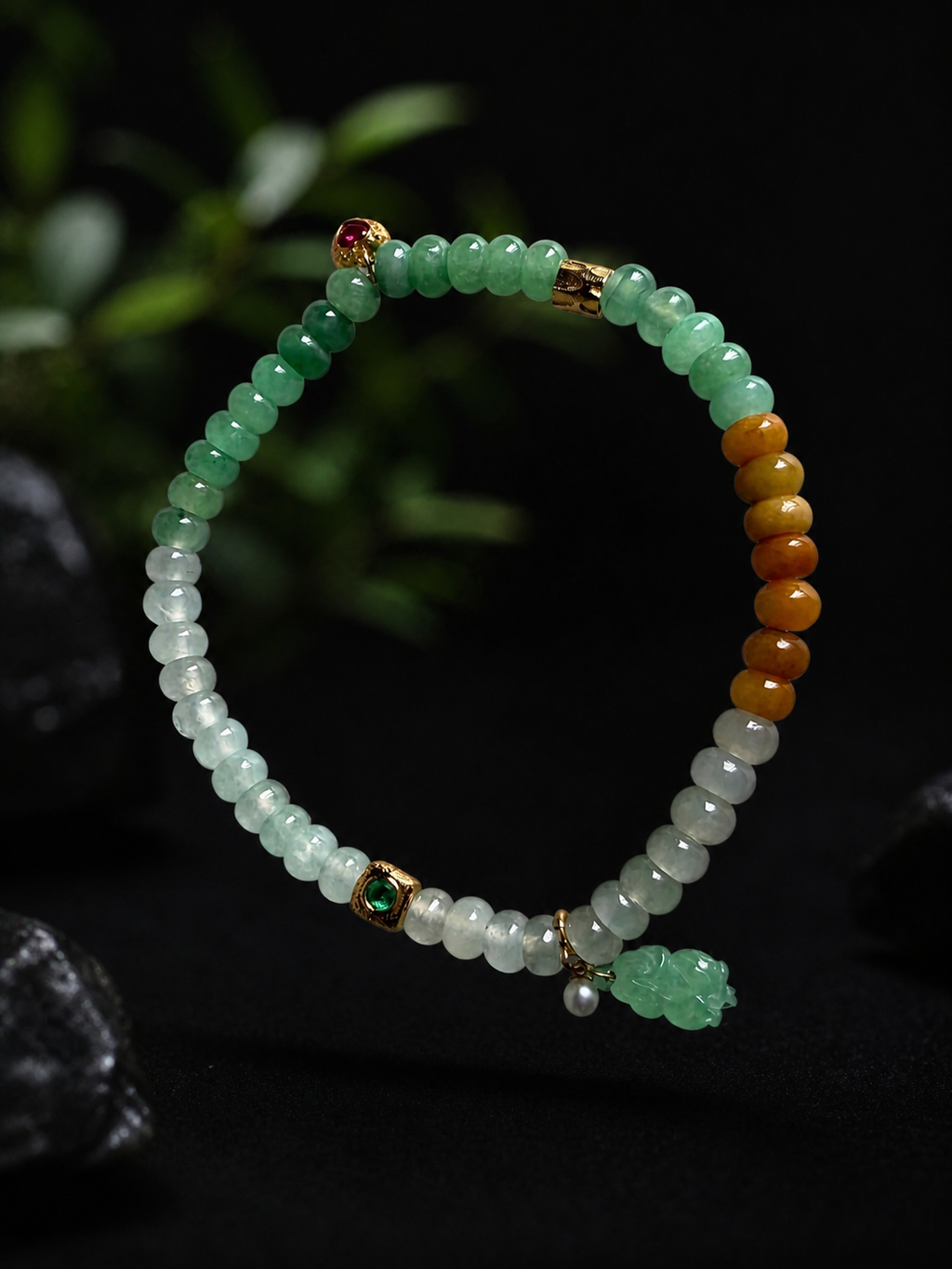 Jadeite beaded bracelet with green, white, and amber beads, gold charms, and tassel