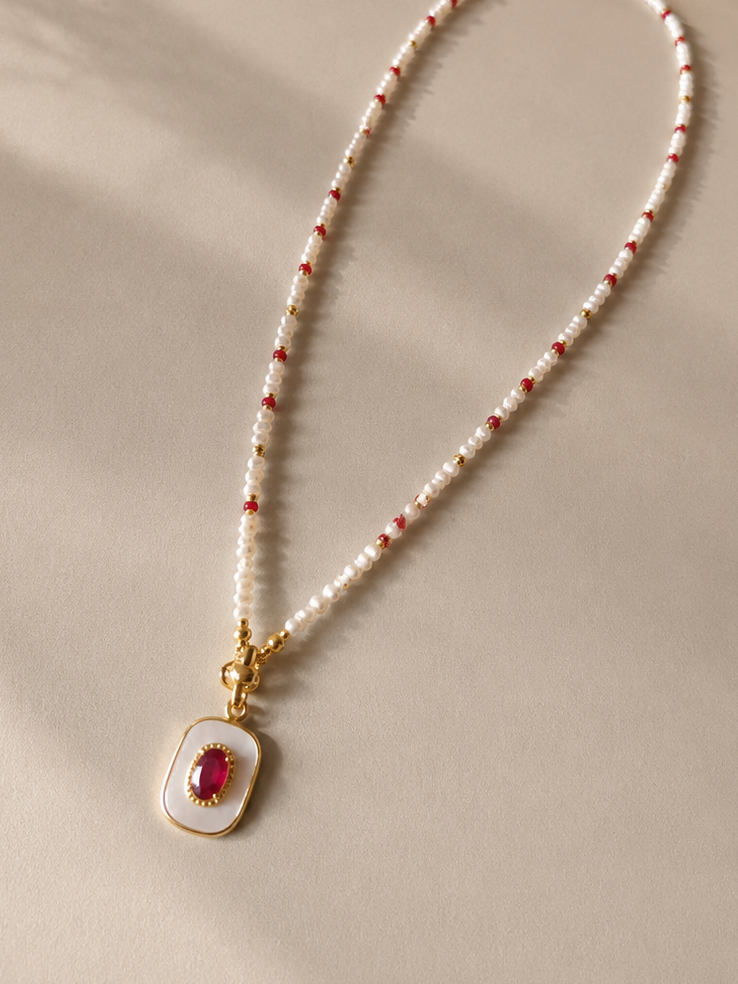 Gold keshi pearl necklace with white pearls and ruby red beads, oval ruby charm pendant